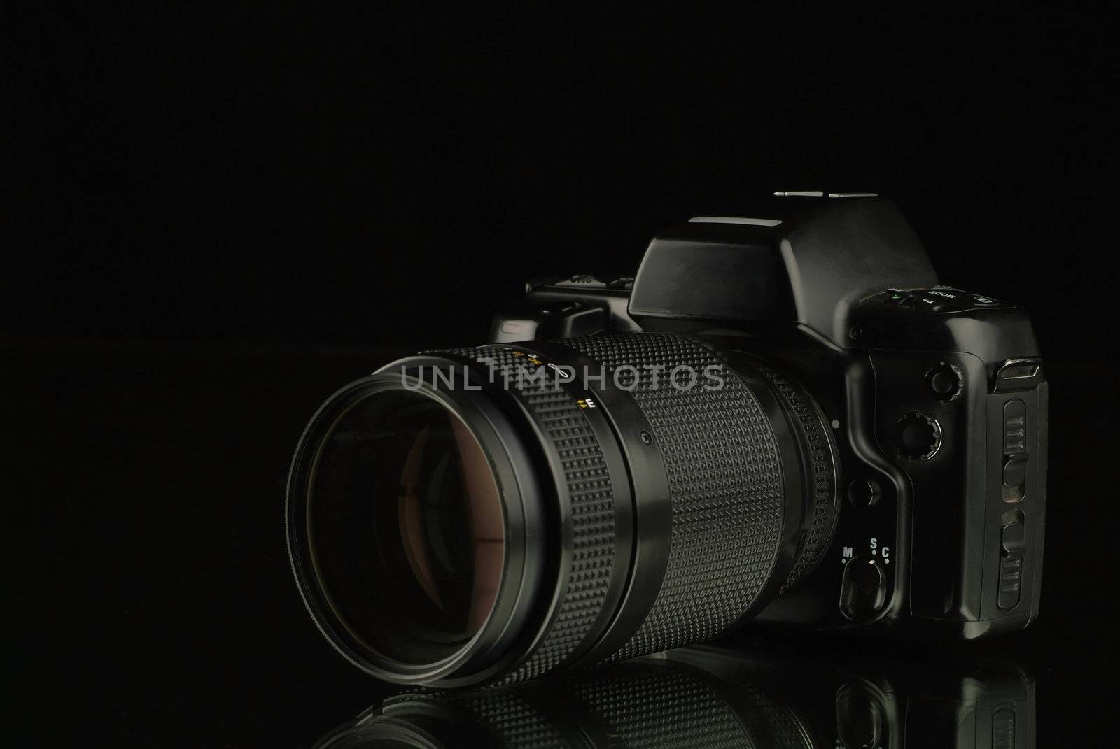 Close-up of Camera with Reflection on Mirror with Black Background