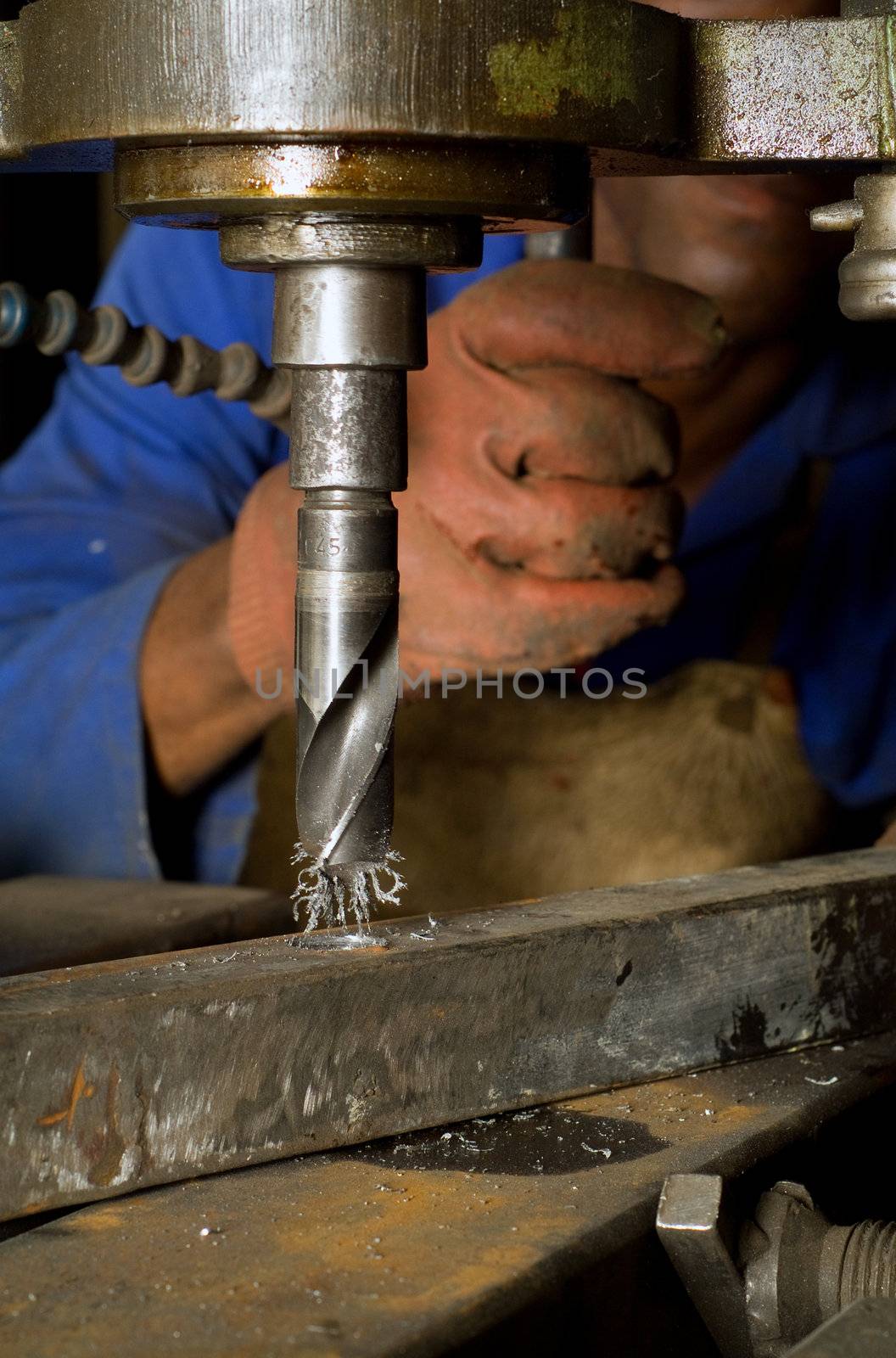 South African or American worker engineer working with industrial drill press