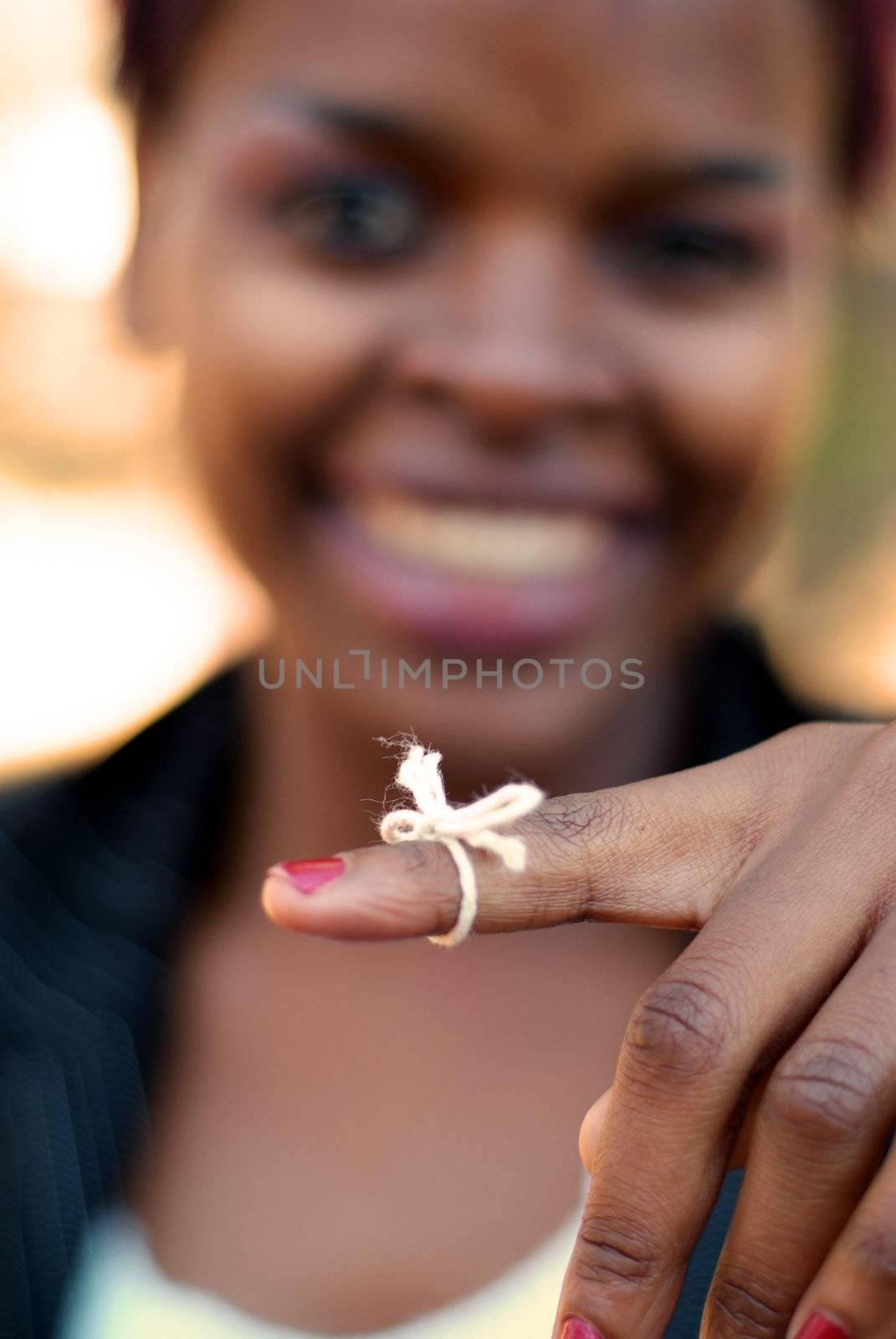 African American businesswoman with string tied to finger to remember important task