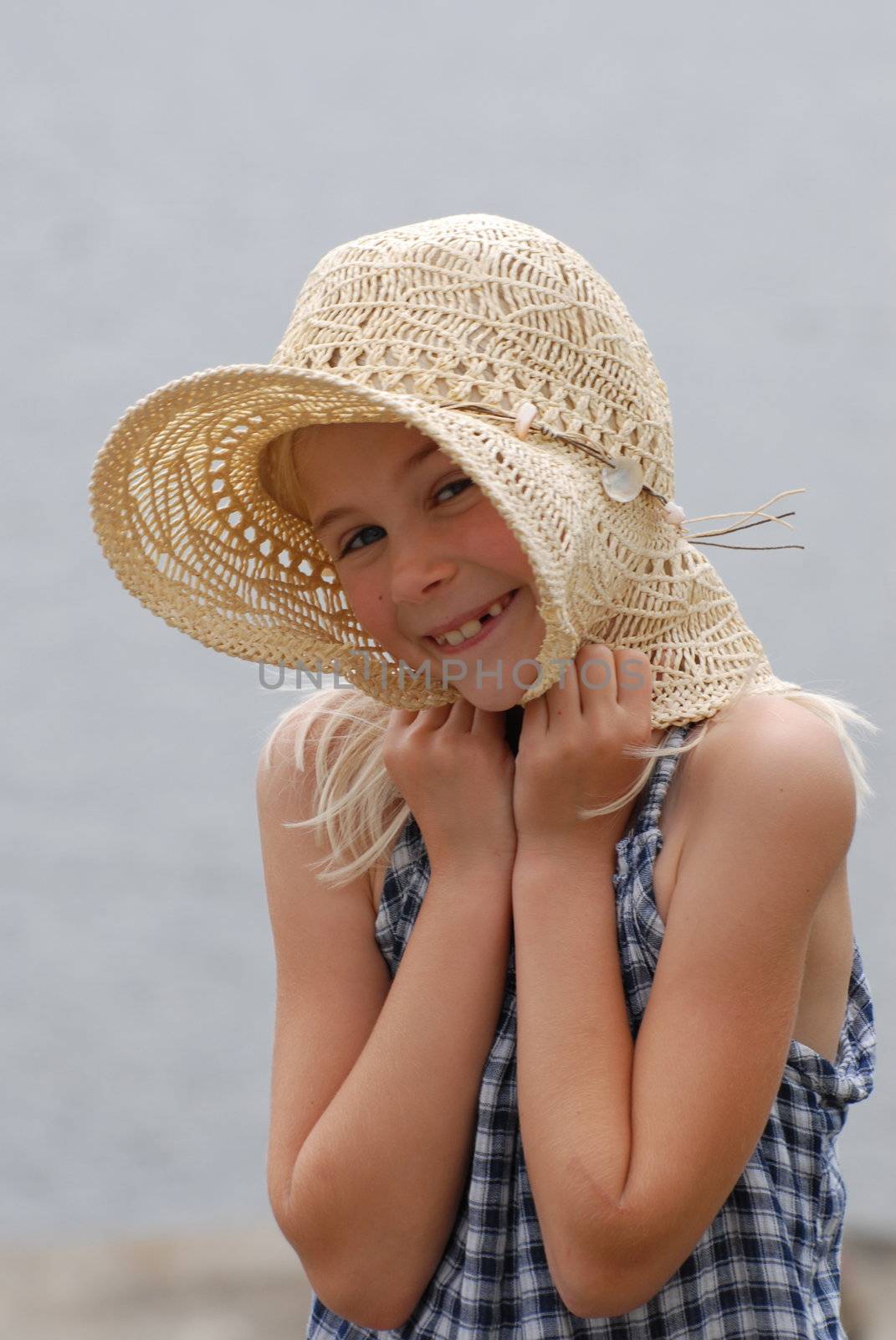 Smiling girl with straw hat by Bildehagen