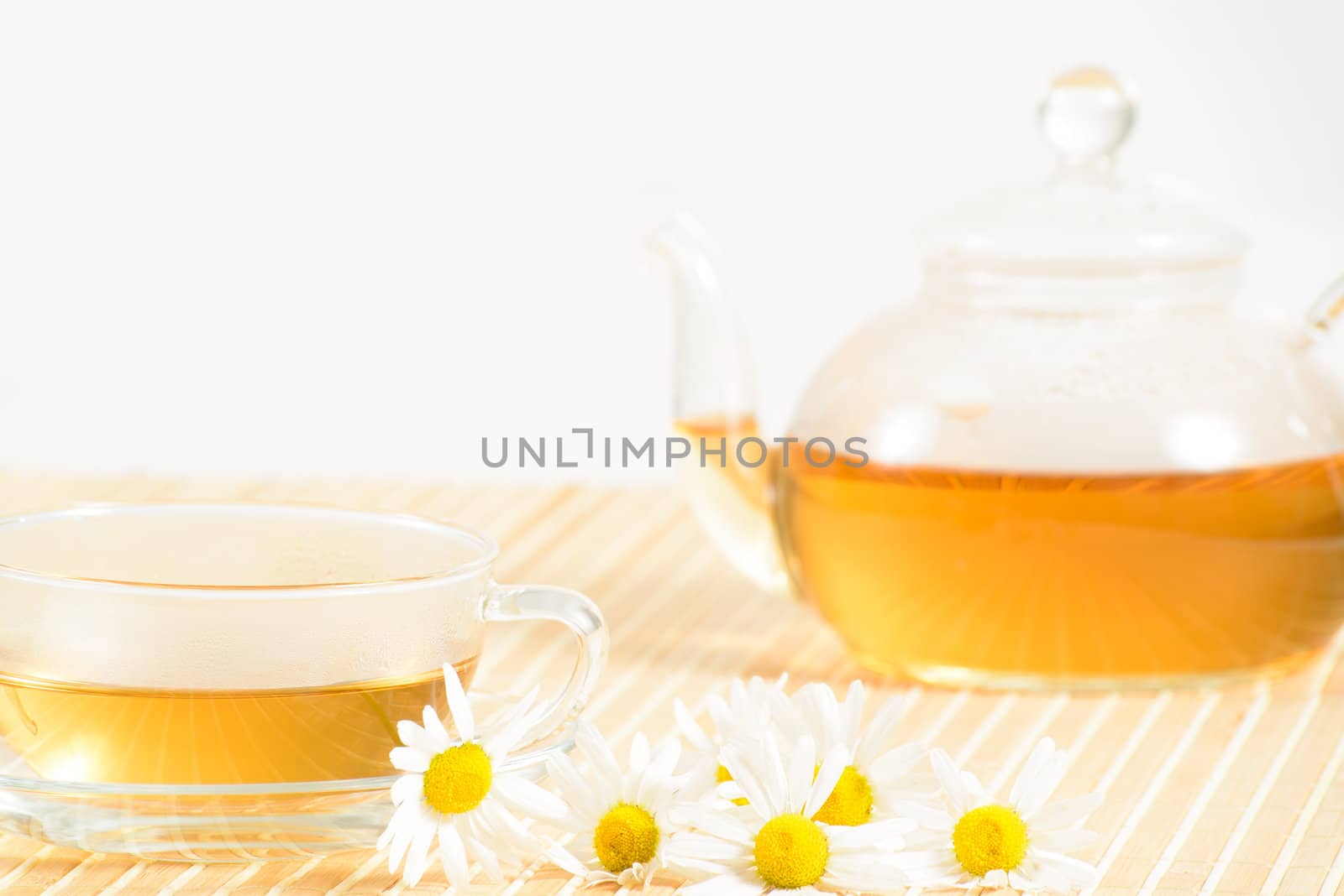 A teacup and a teapot with herbal chamomile tea