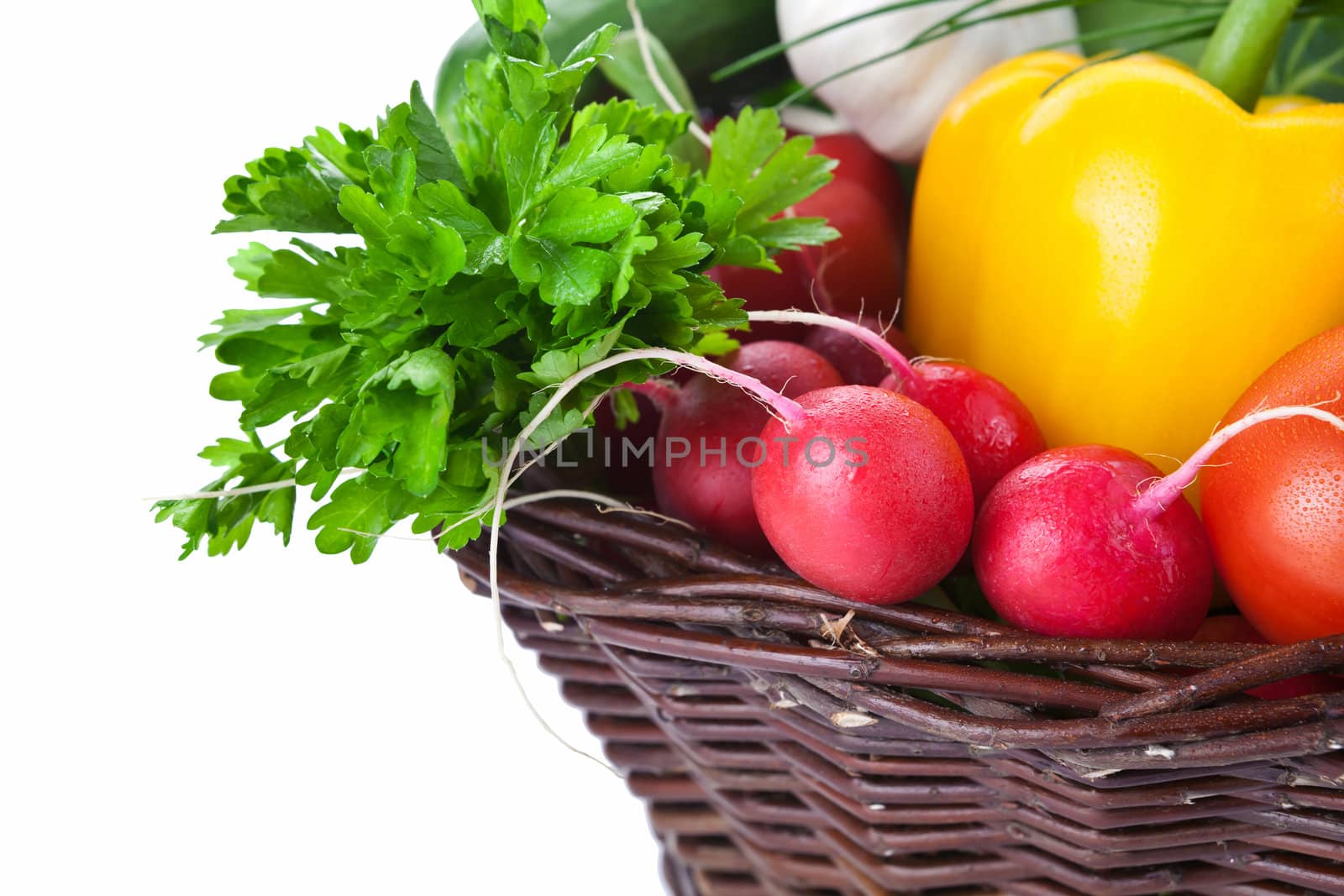 Fresh vegetables in a wicker basket. Isolated on white background. Copy space