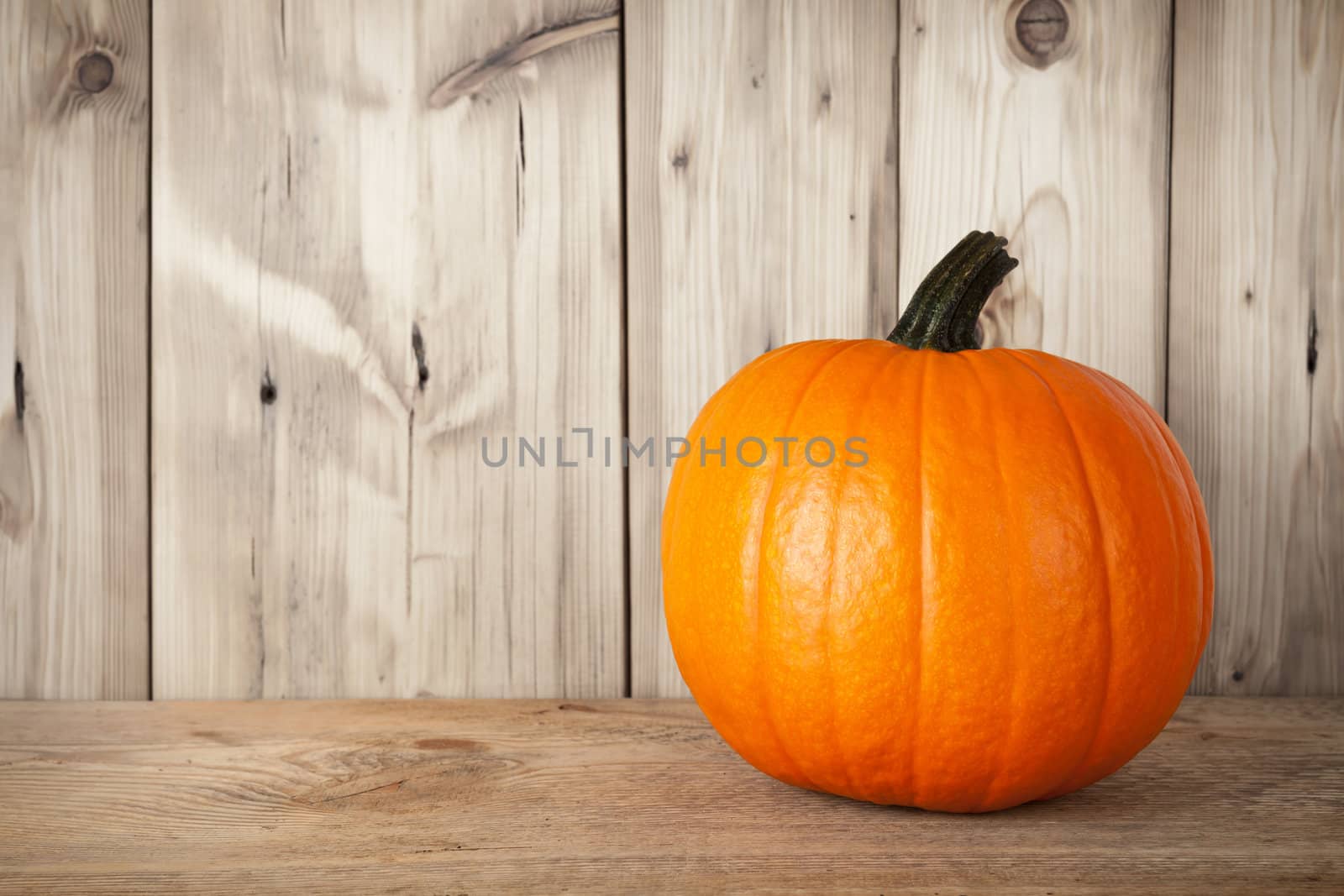 Pumpkin on wooden table against wooden background