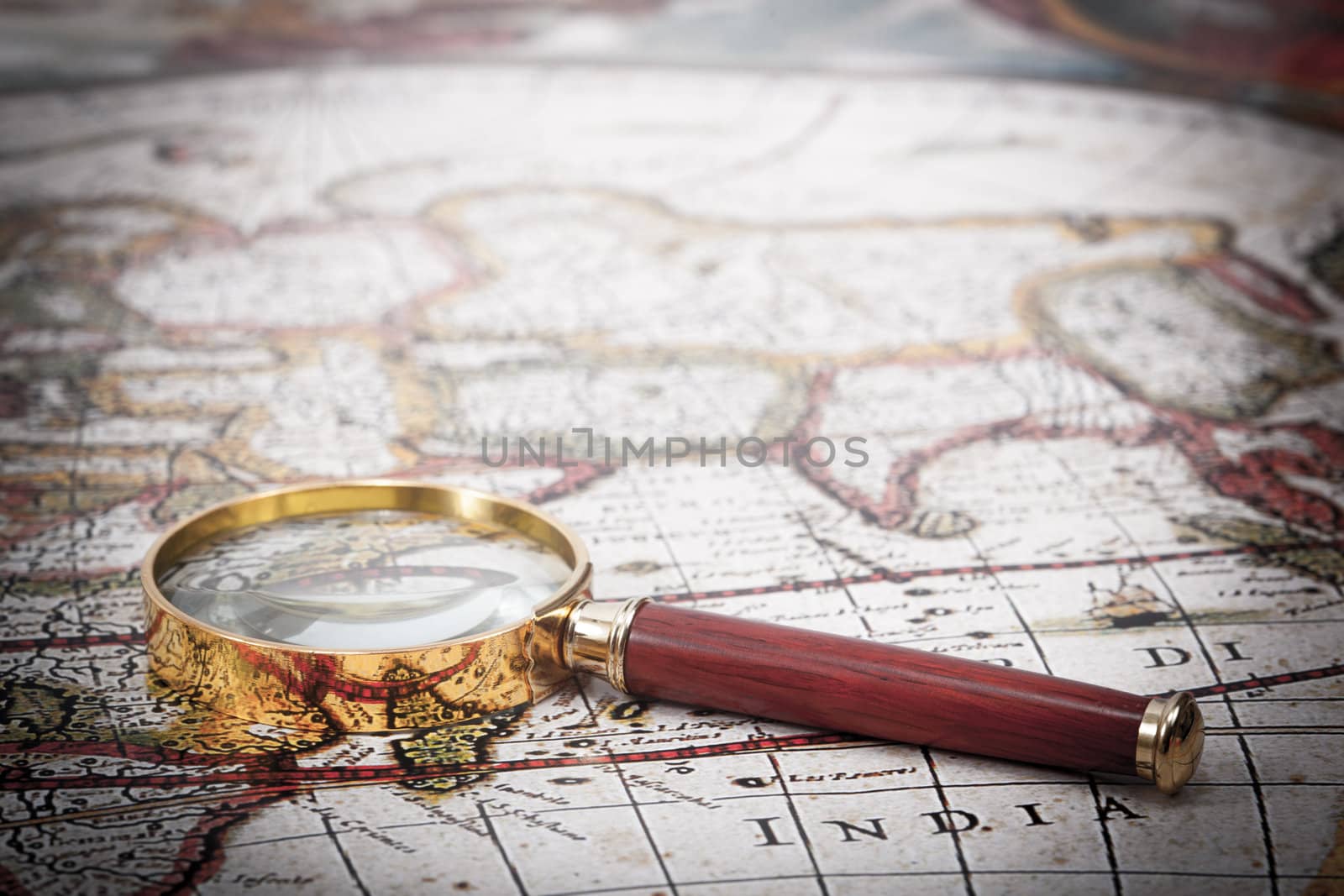 A beautiful antique map with an old magnifying glass with golden details.