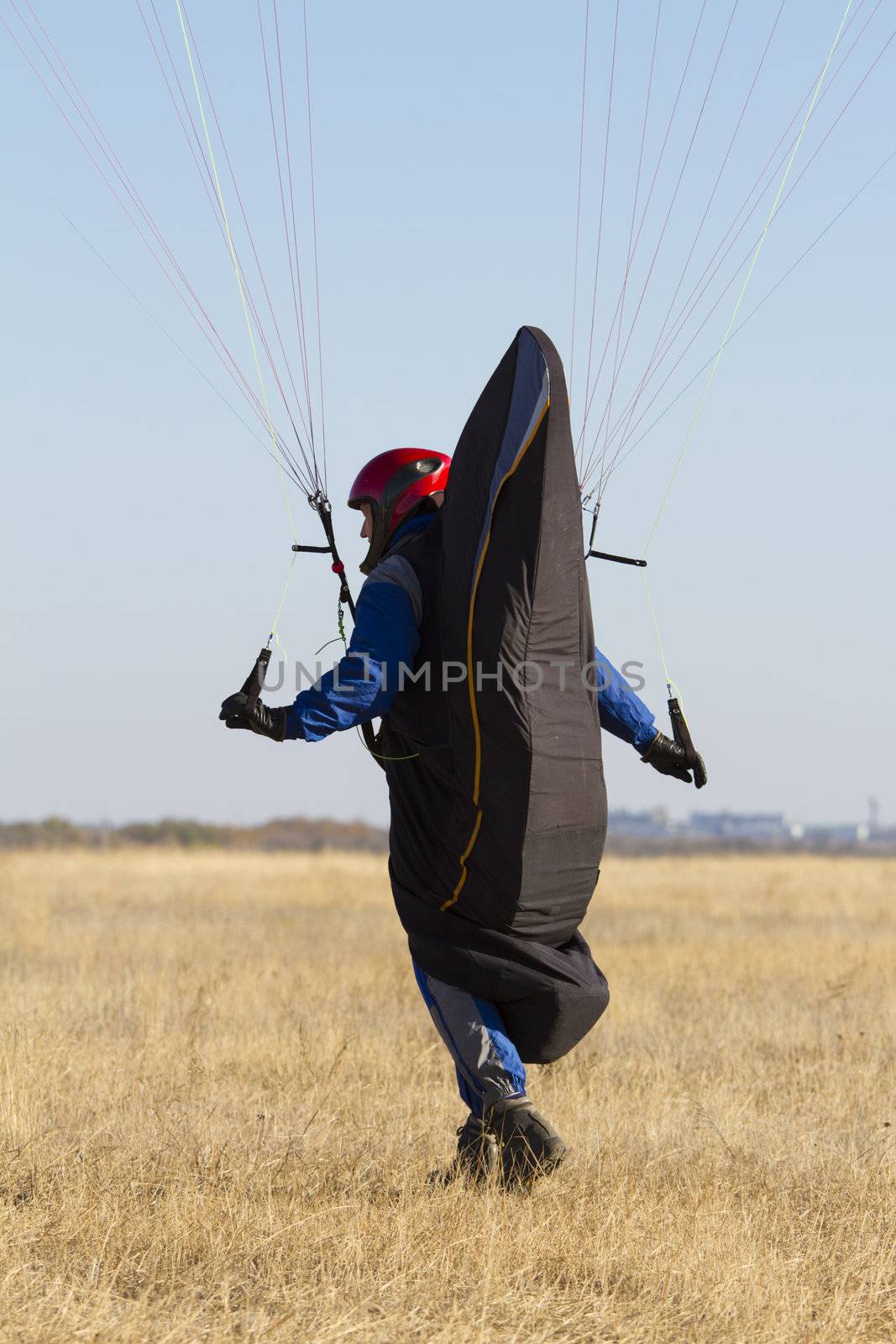 A male paraglider pilot prepares for flight