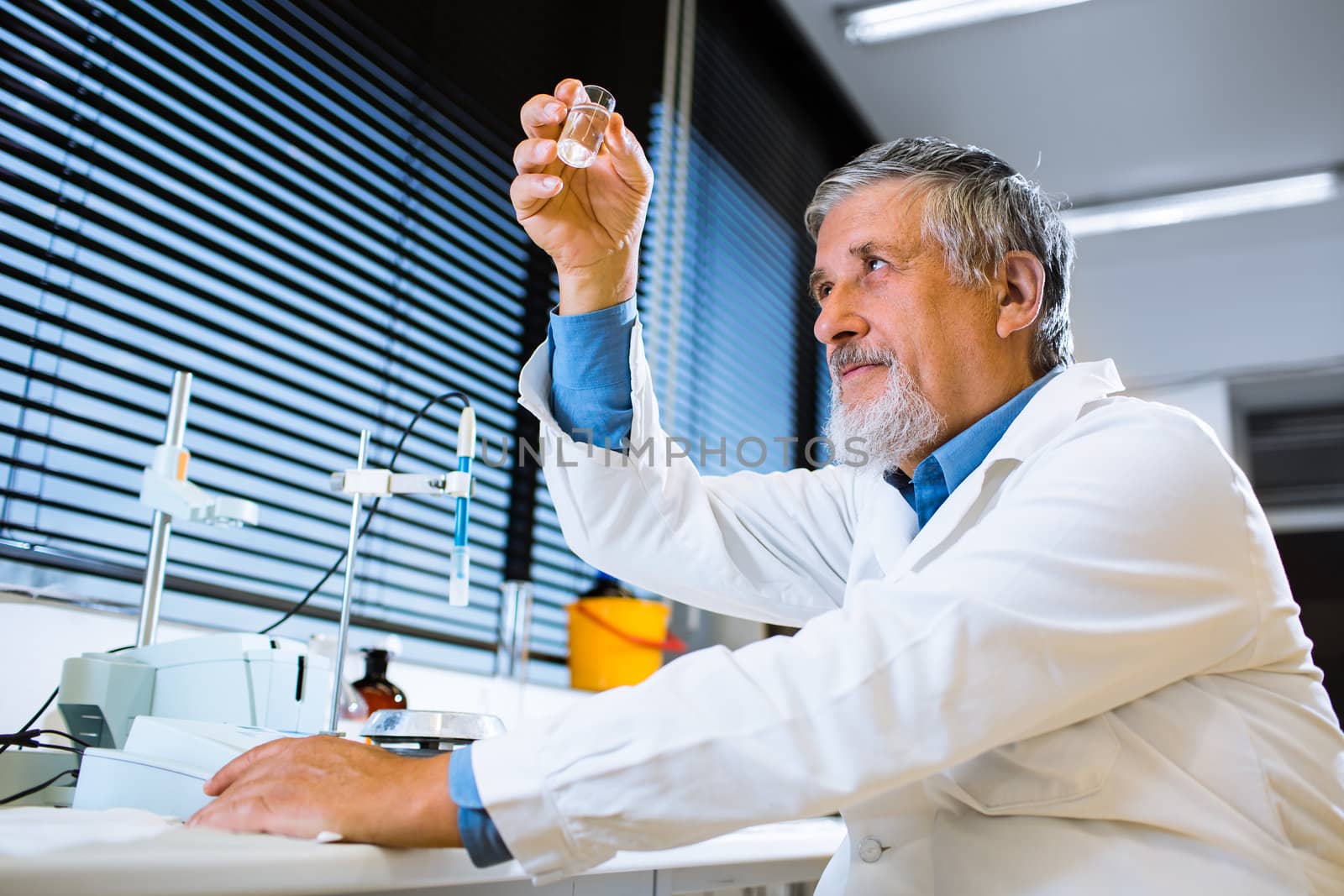 Senior male researcher carrying out scientific research in a lab (shallow DOF; color toned image)