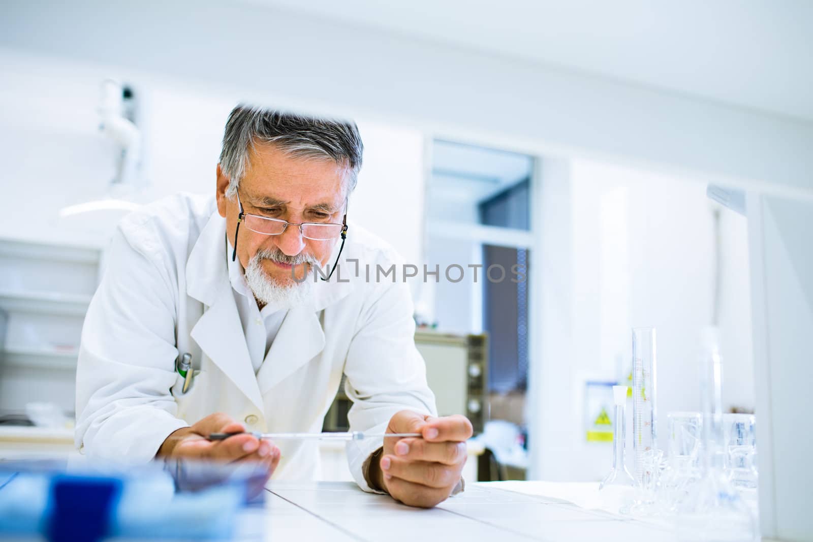 Senior male researcher carrying out scientific research in a lab (shallow DOF; color toned image)