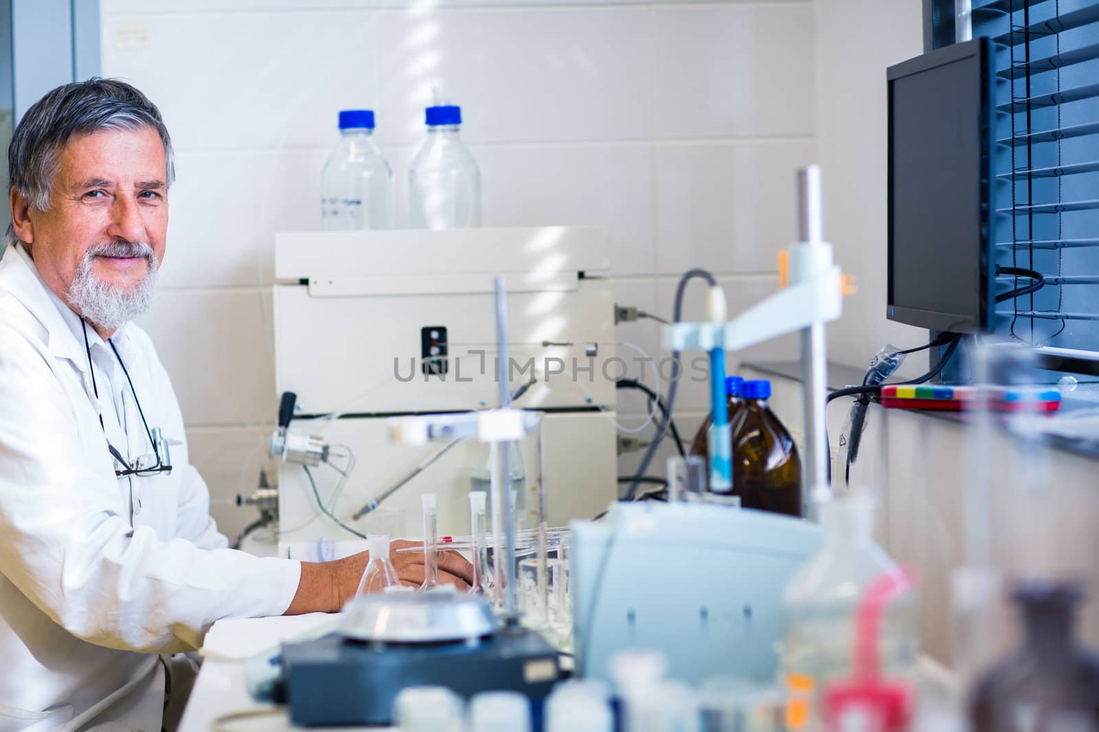 Senior male researcher carrying out scientific research in a lab (shallow DOF; color toned image)