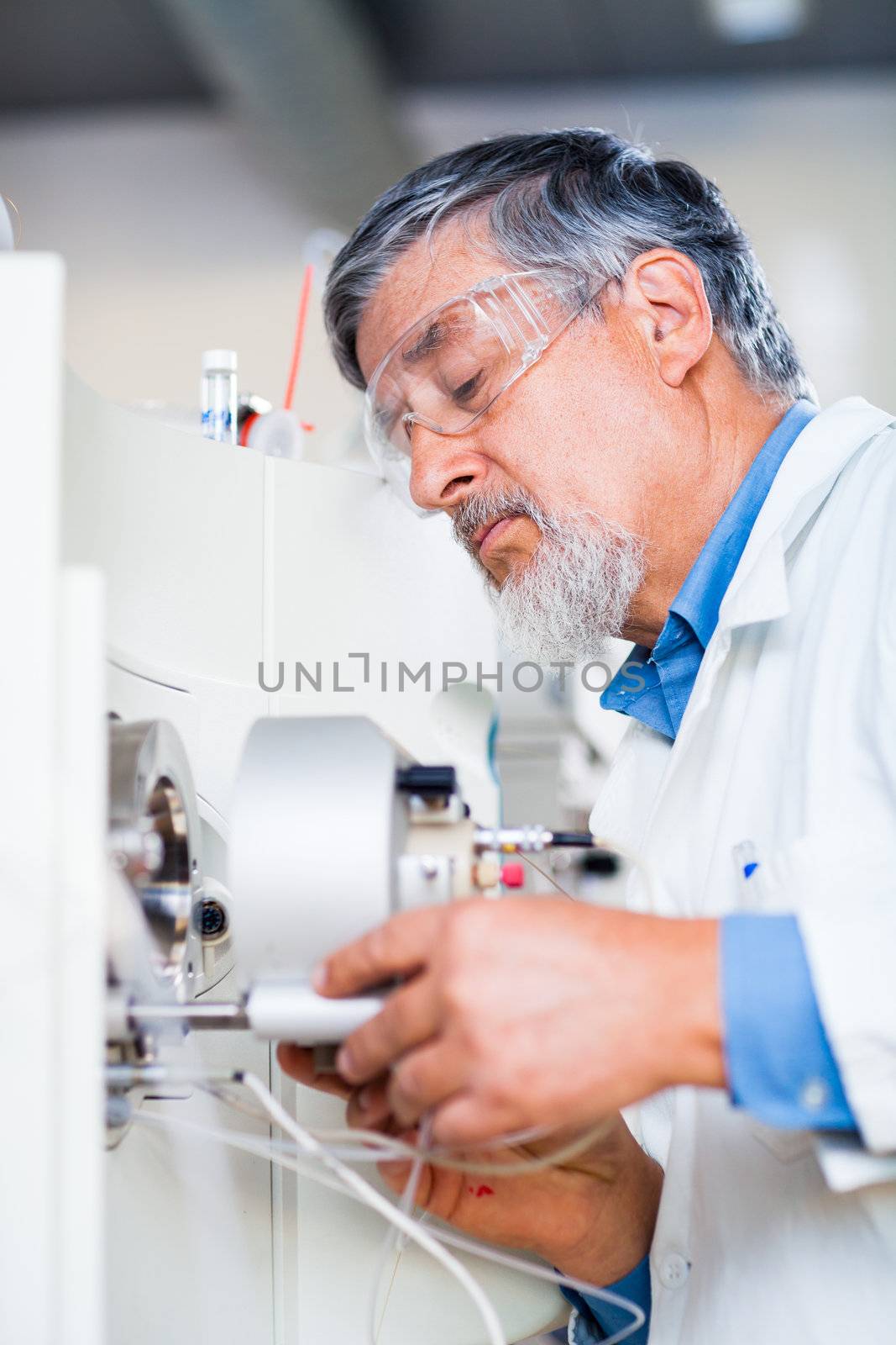 Senior male researcher carrying out scientific research in a lab (shallow DOF; color toned image)