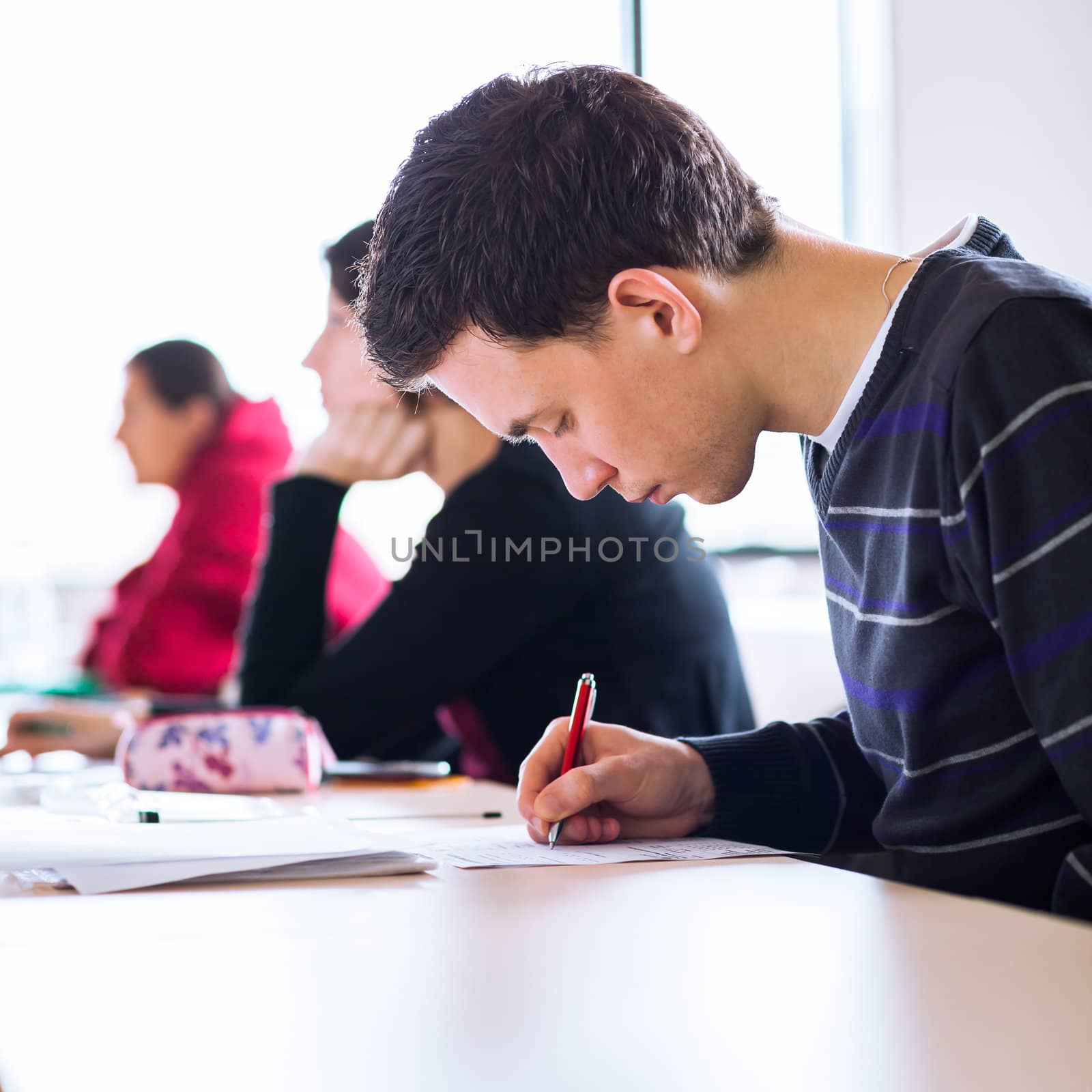 young, handsome male college student sitting in a classroom full by viktor_cap