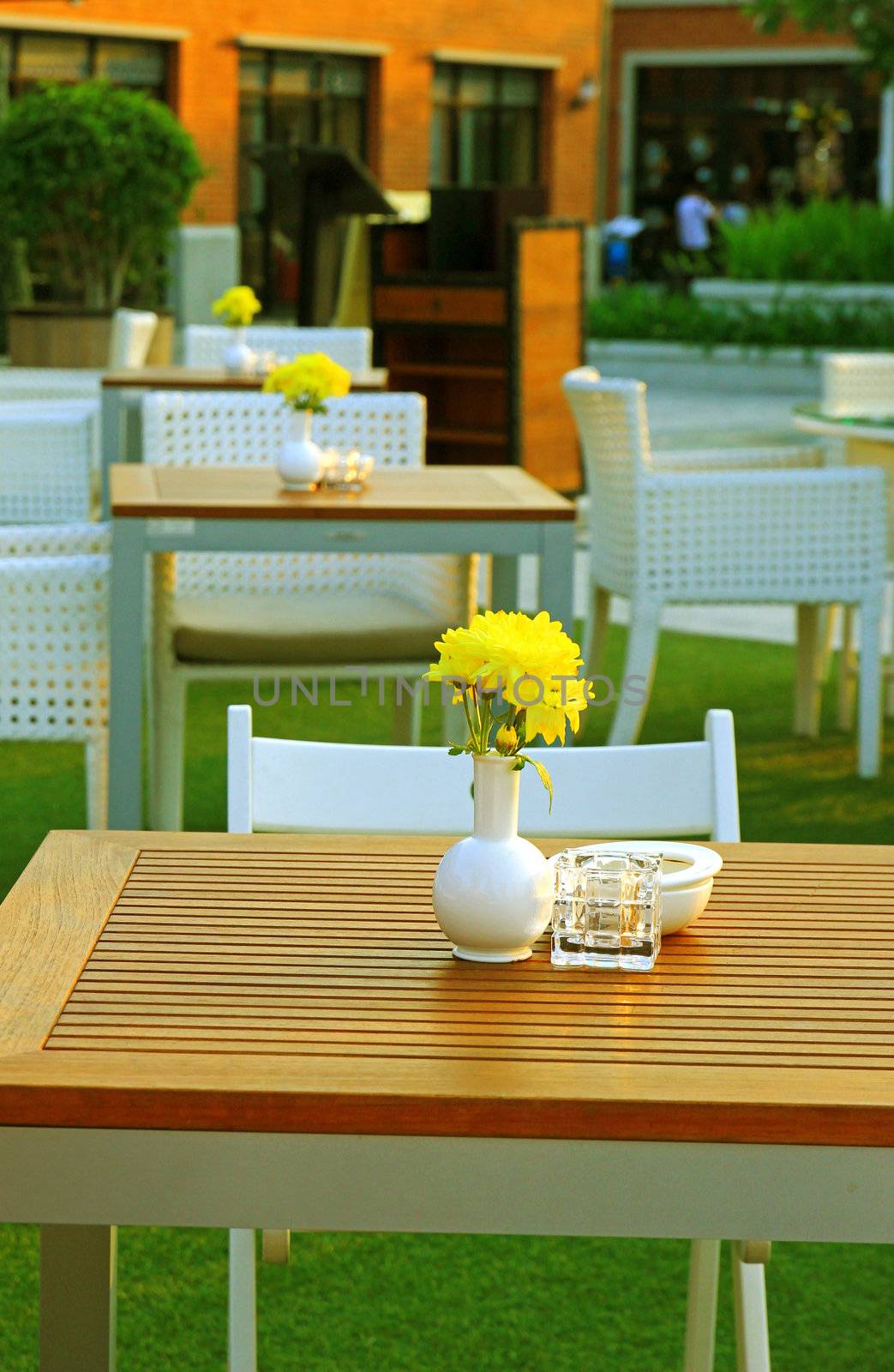 Table and chair setting with flower in outdoor restaurant by nuchylee