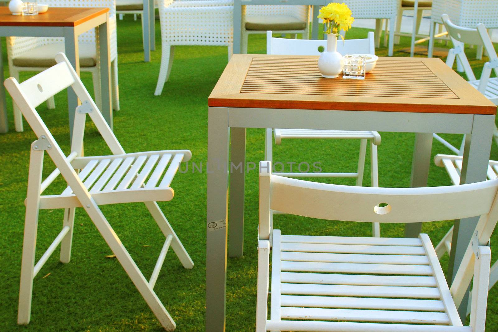 Table and chair setting with flower in outdoor restaurant by nuchylee