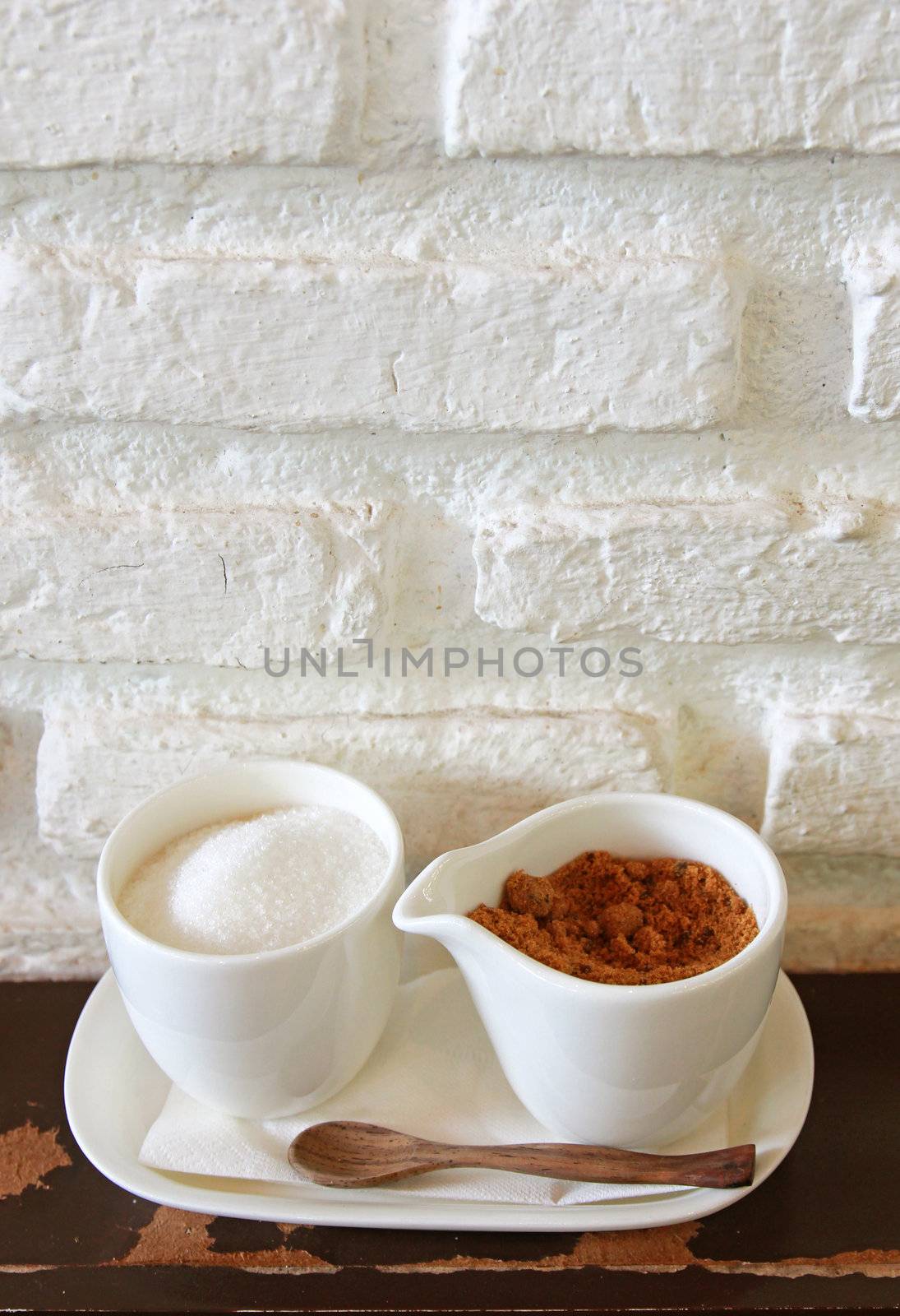 Brown and white sugar in cup with wooden spoon by nuchylee