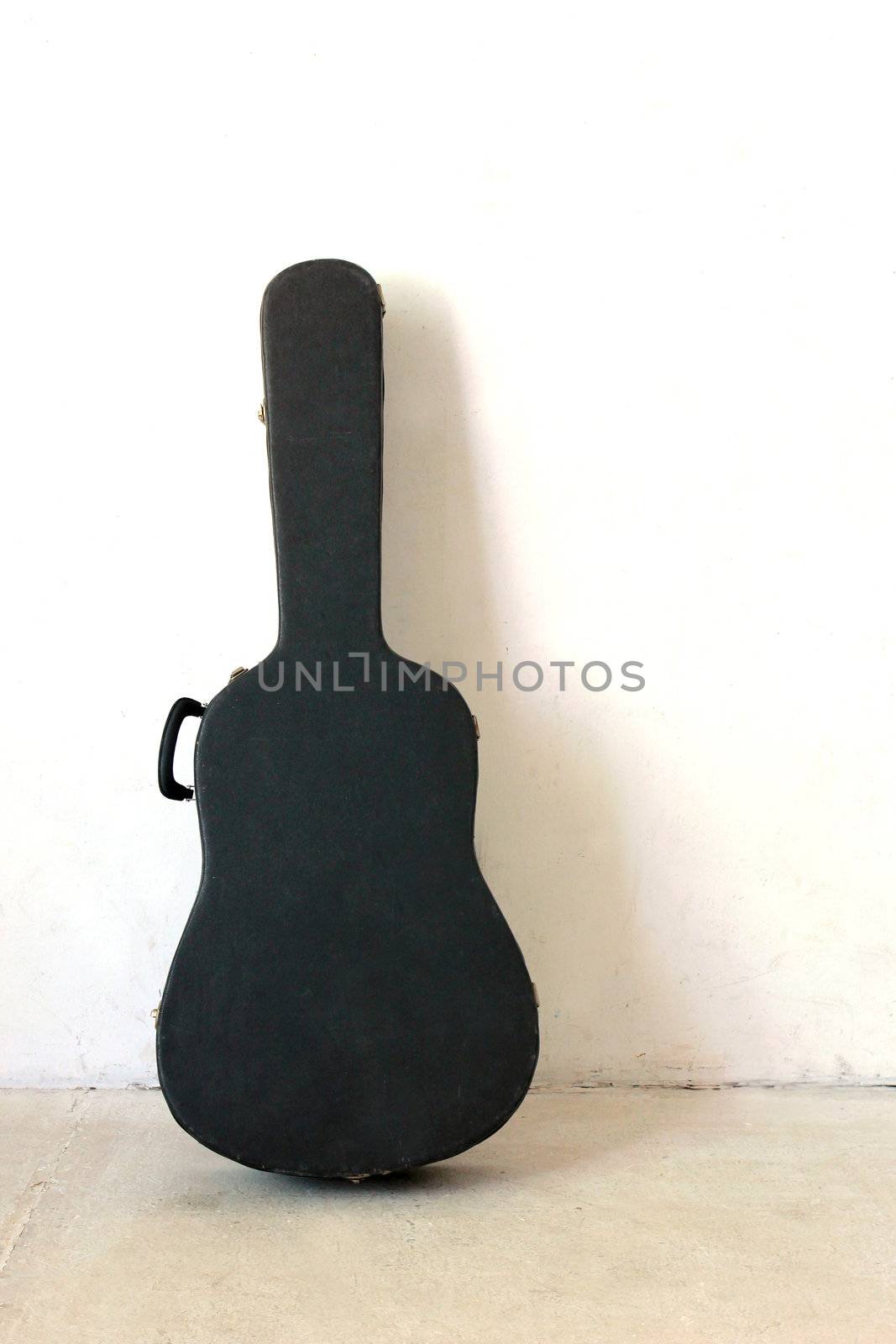 The Old Guitar case on white wall