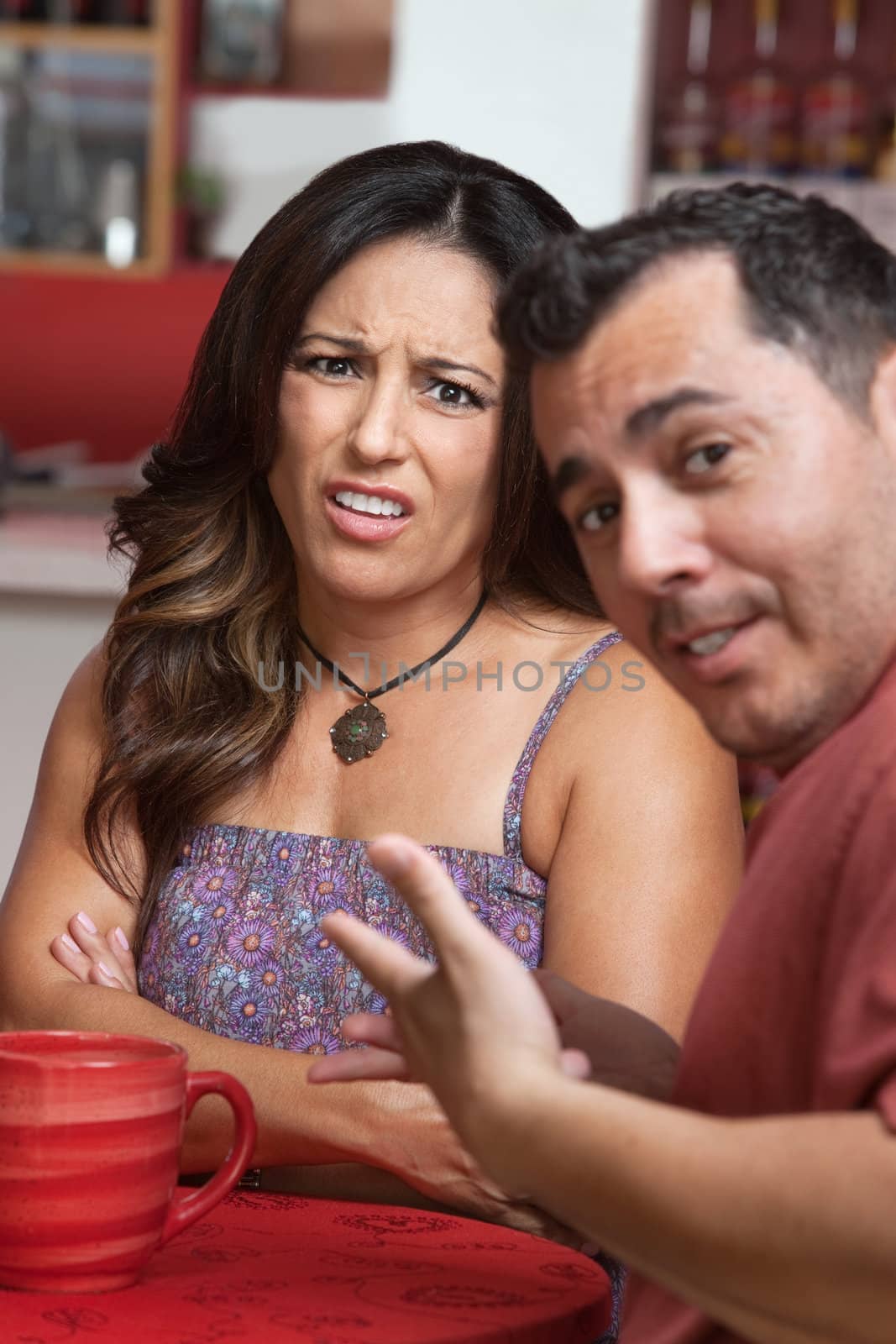 Disgusted Hispanic woman in cafe with man