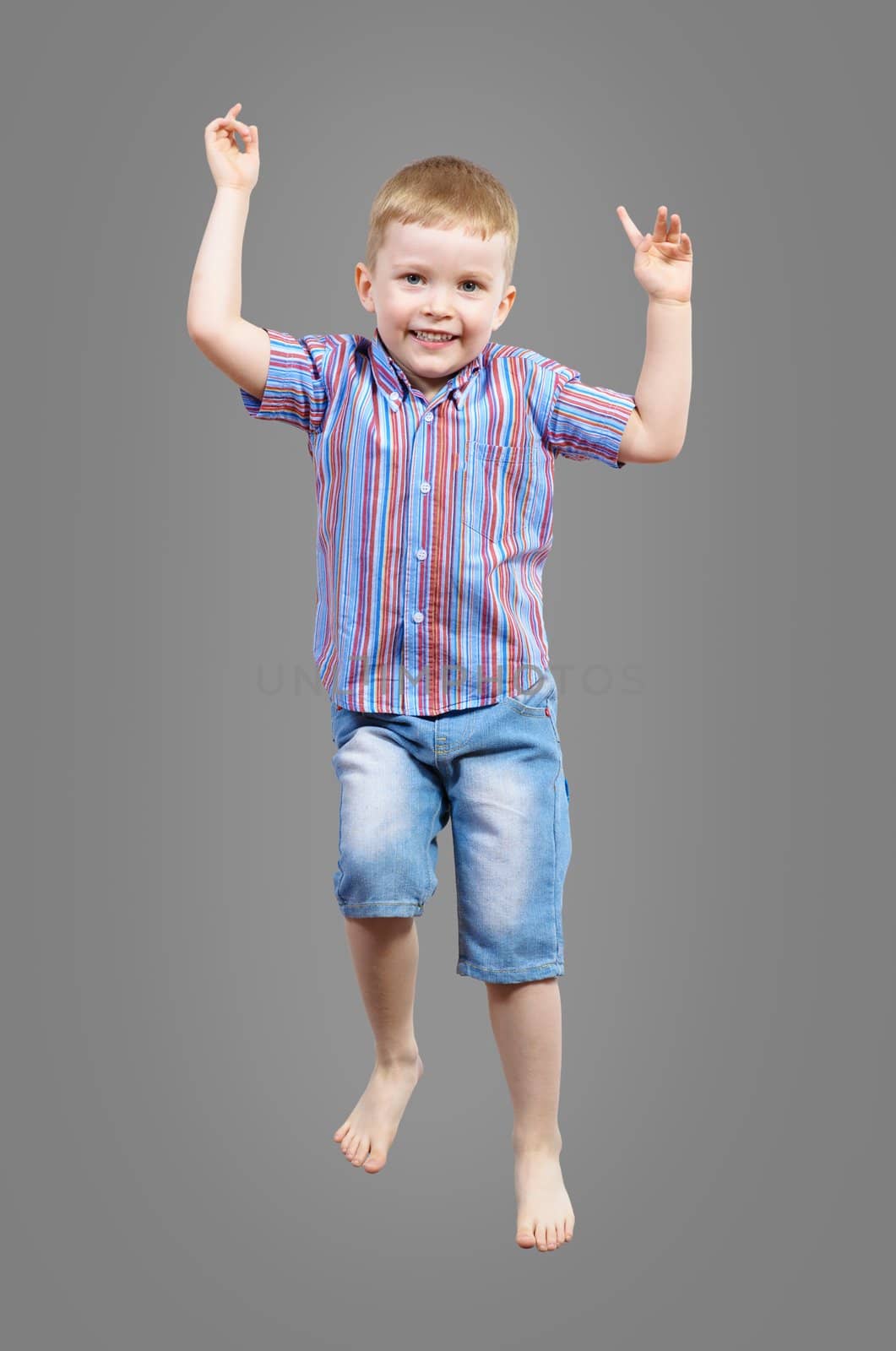 boy jumping hands up smiling and happy