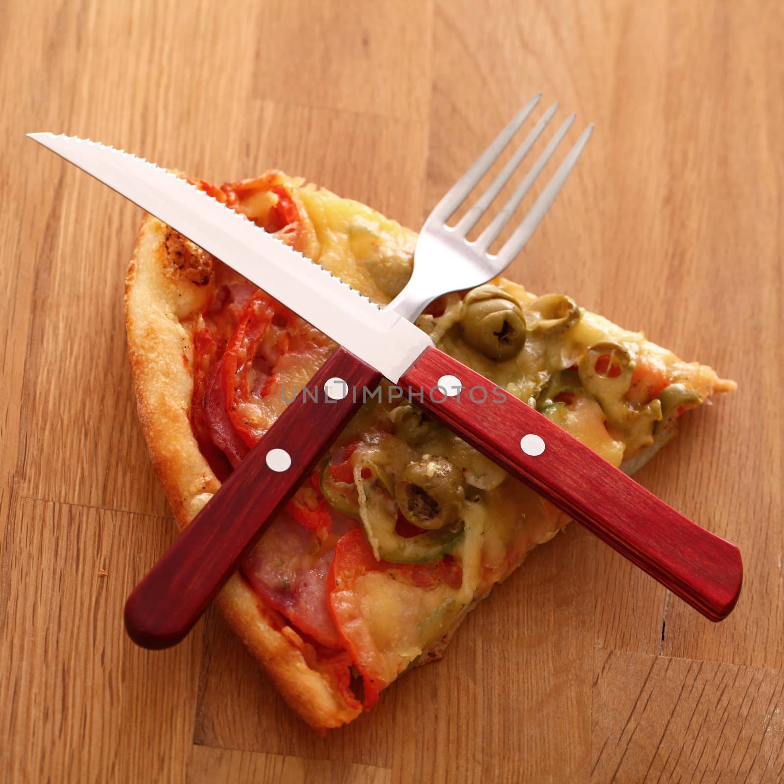 Slice of fesh italian pizza with fox and knife over wooden background