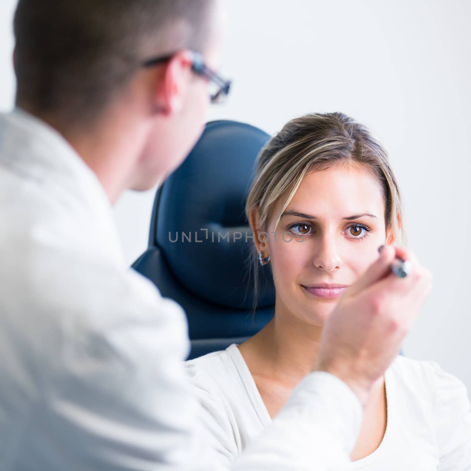 optometry concept - pretty young woman having her eyes examined by an eye doctor