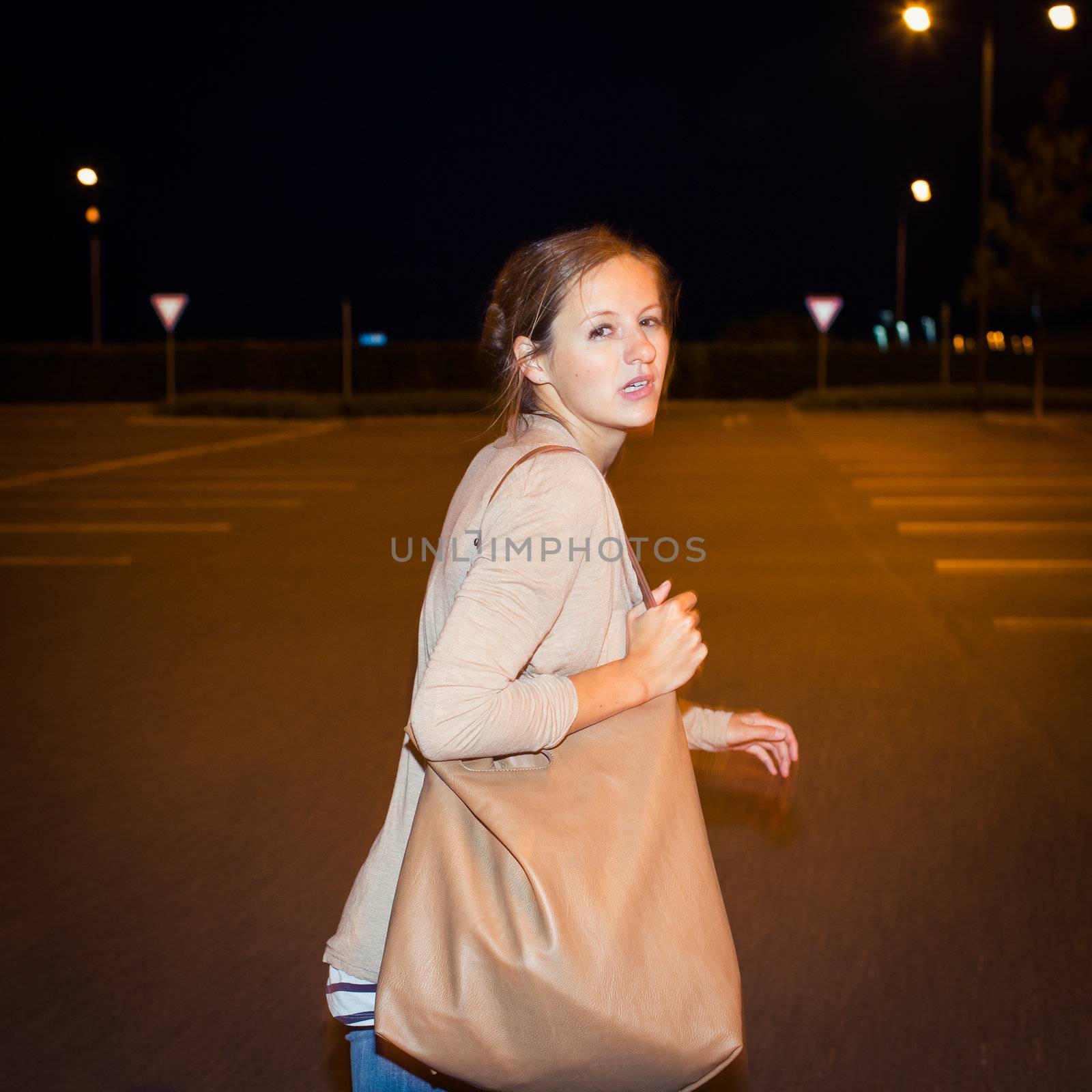 Scared young woman running from her pursuer in a deserted parkin by viktor_cap