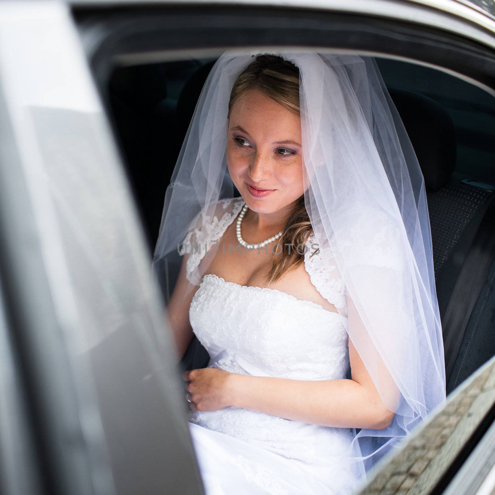 Portrait of a beautiful young bride waiting in the car by viktor_cap
