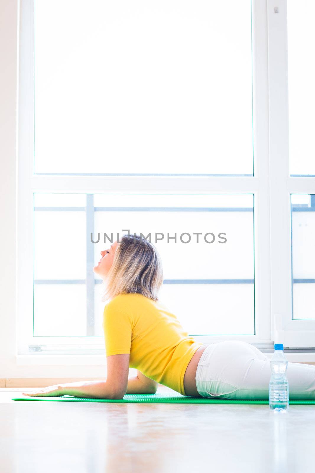 Pretty young woman doing YOGA exercise at home