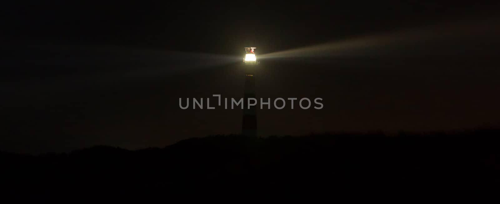 Lighthouse in the dark on the dutch isle of Ameland, Holland, room for text