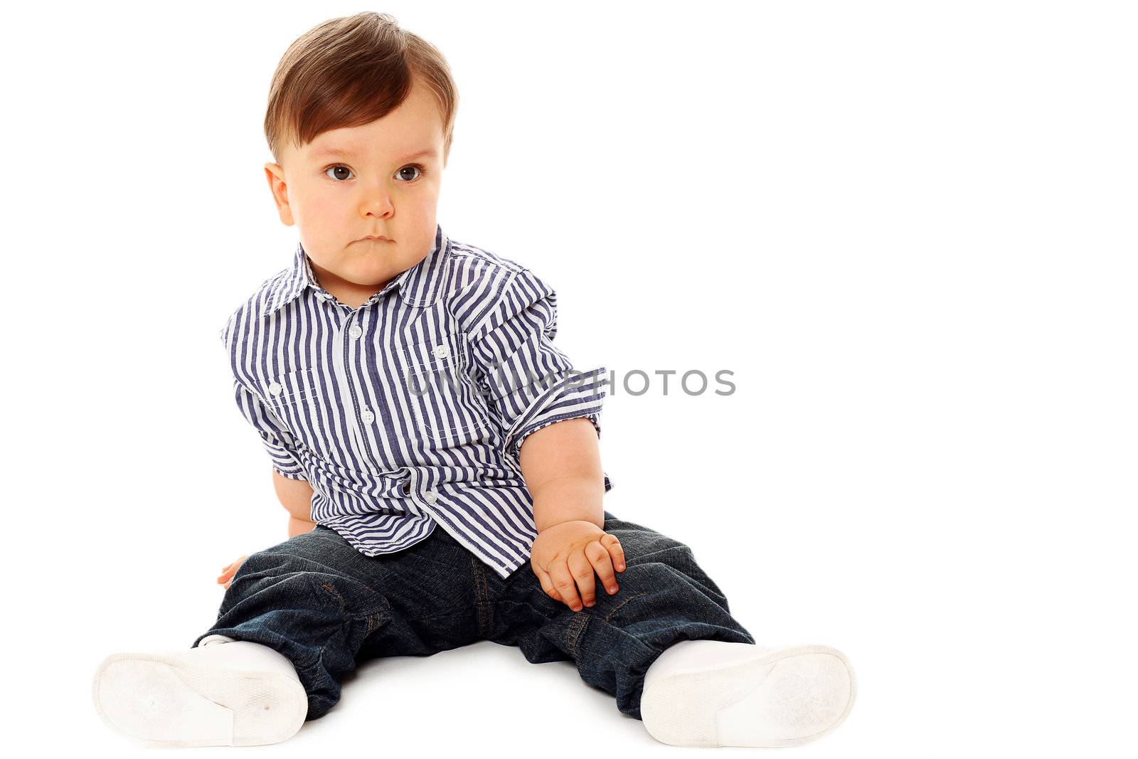 Beautiful serious little boy in jeans isolated over white background