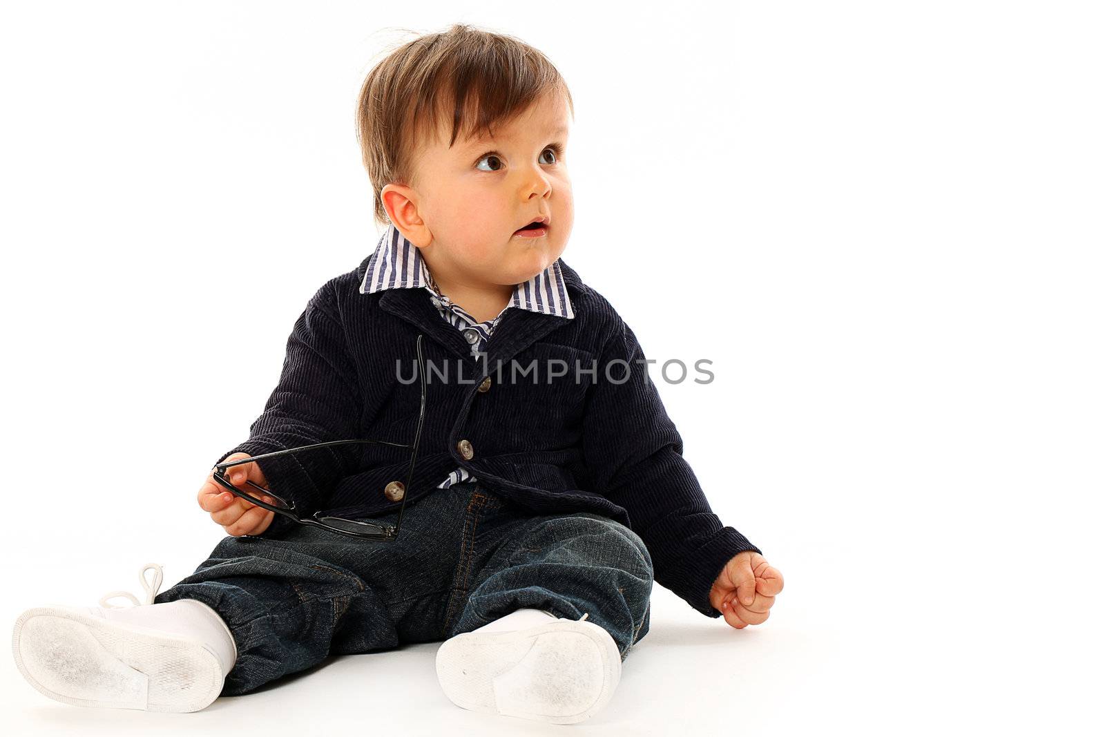 Beautiful serious little boy in a coat and jeans isolated over white background