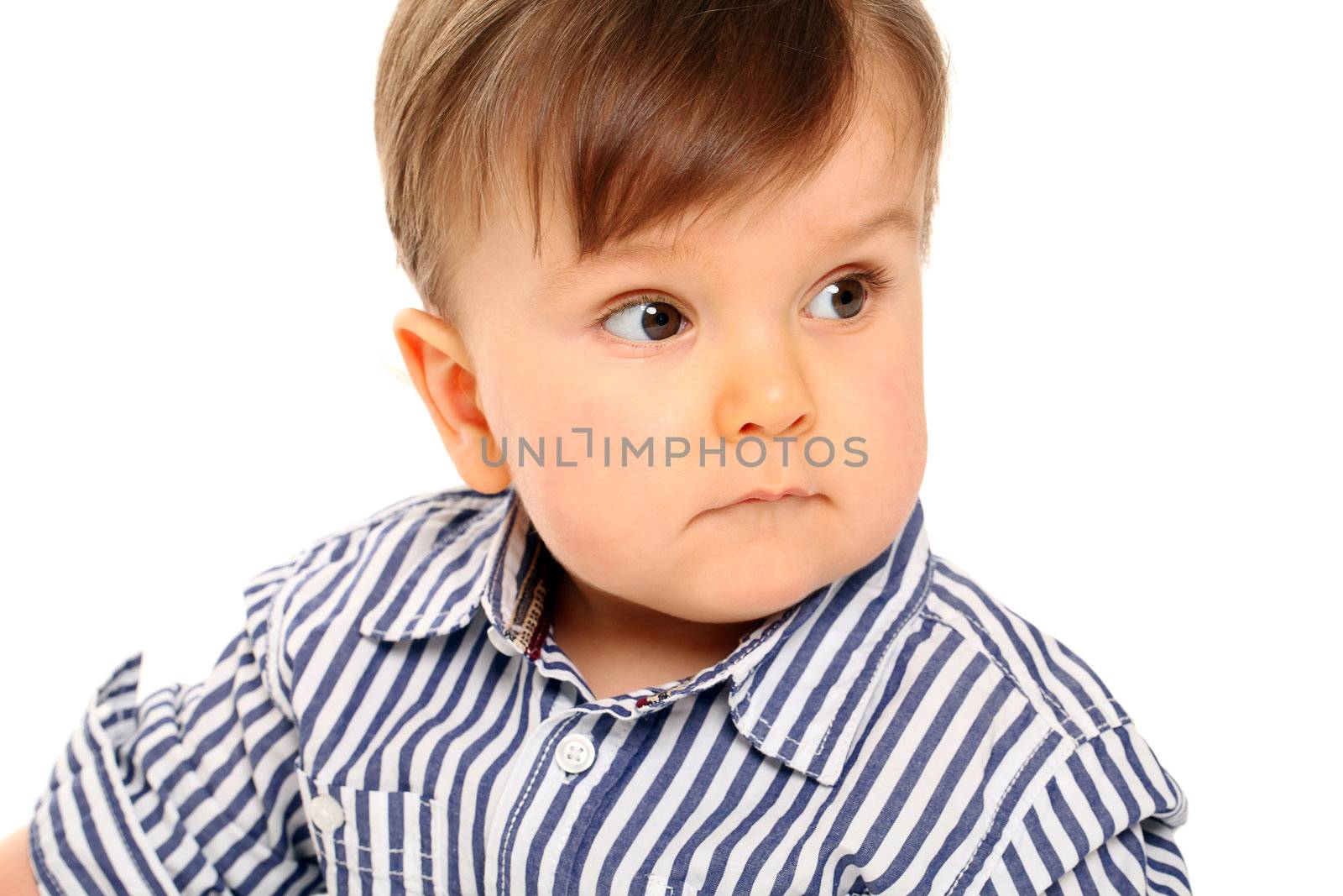 Beautiful serious little boy in jeans isolated over white background
