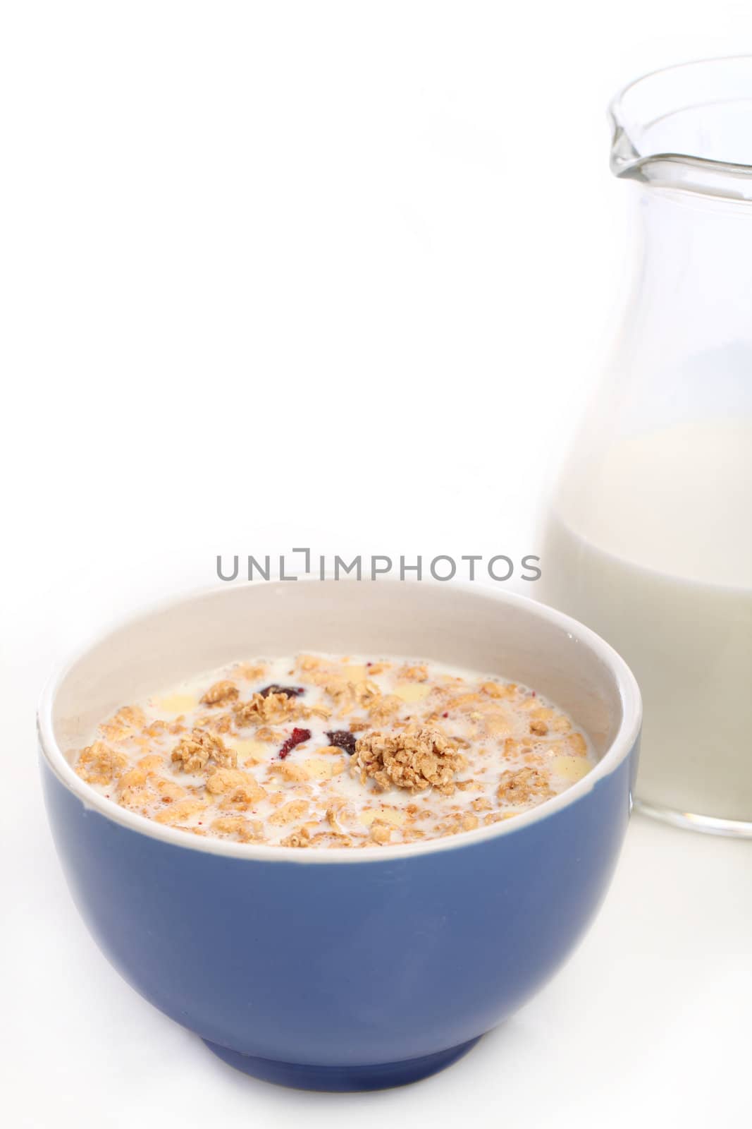 Image of blue bowl with healthy muesli and fresh milk isolated on white background