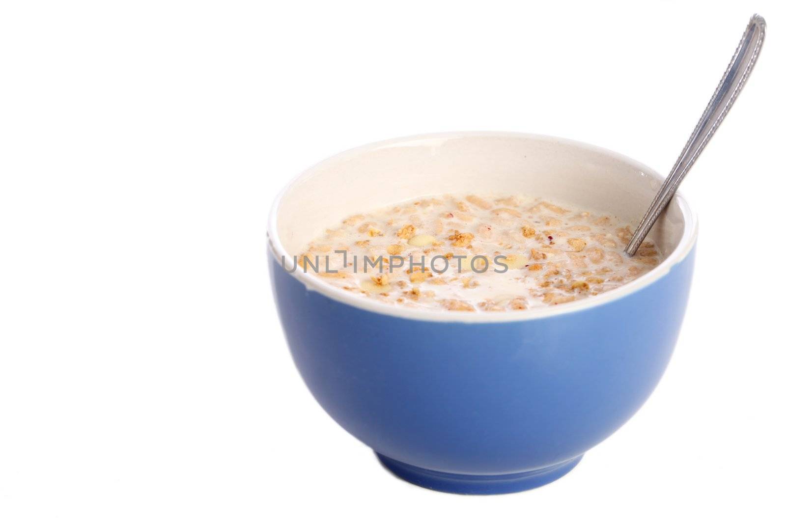 Image of blue bowl with spoon filled with healthy muesli and milk isolated on white background