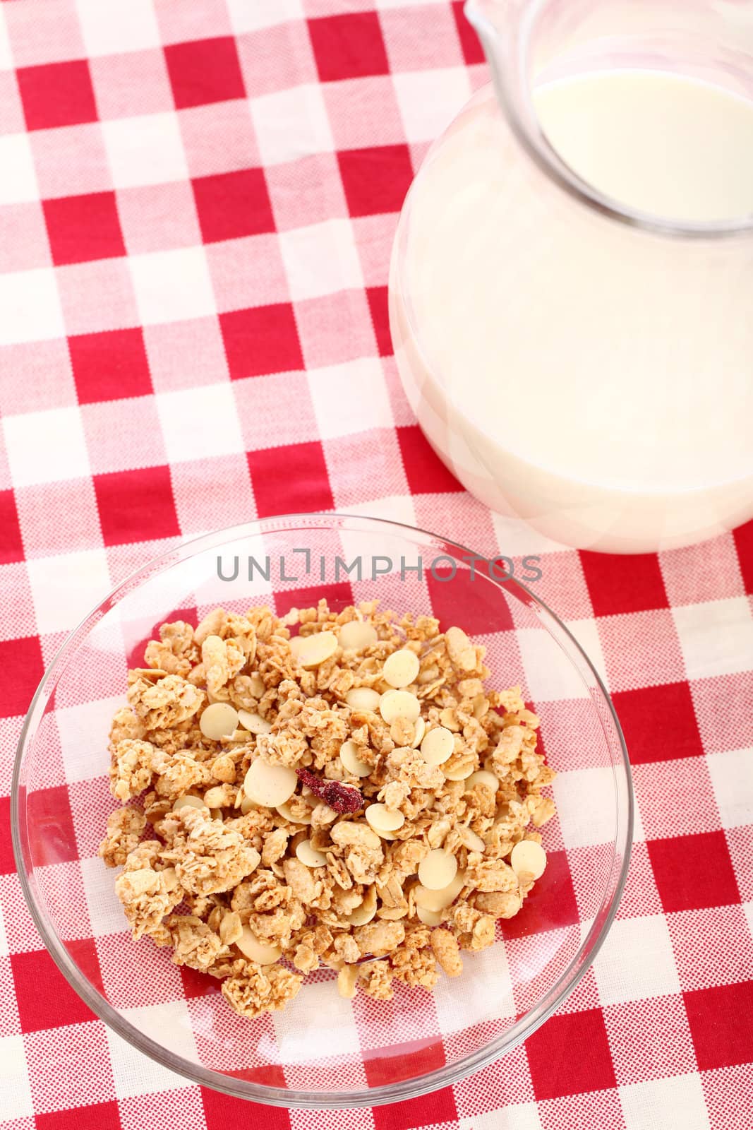 Healthy wholegrain muesli in a plate and a cup of milk on a squared tablecloth