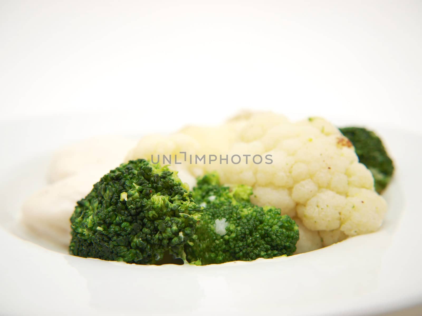 Broccoli and cauliflower isolated on white plate, towards white background by Arvebettum