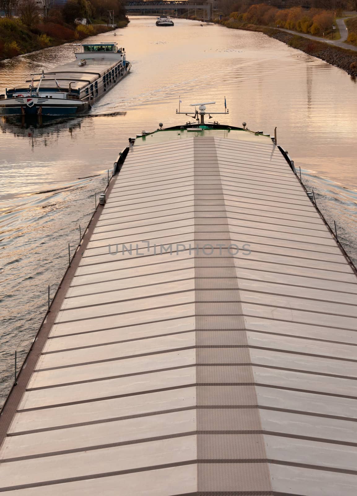 Inland waterway vessels or barges on a busy channel in industrial area