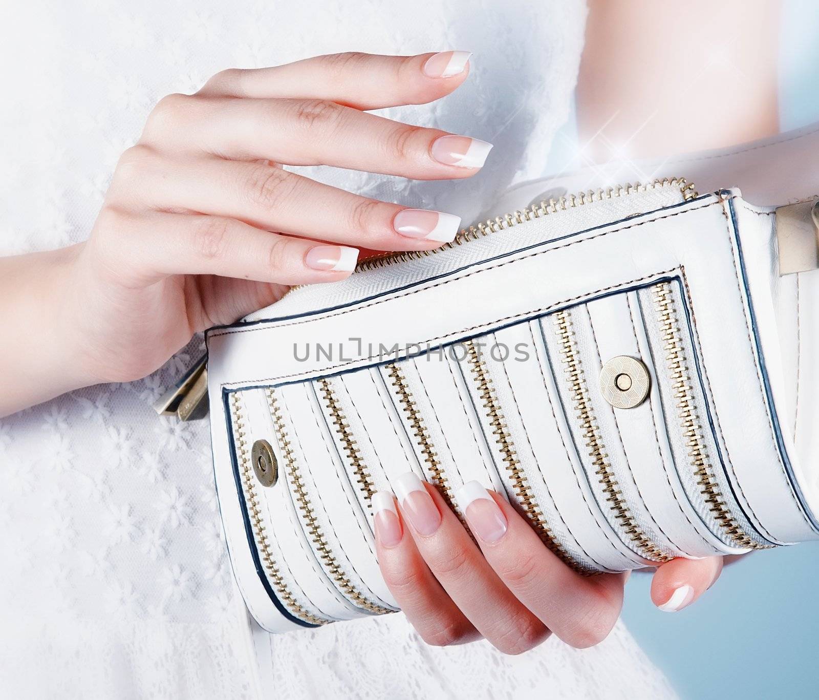 Beautiful female hands with manicure with a handbag by Azaliya