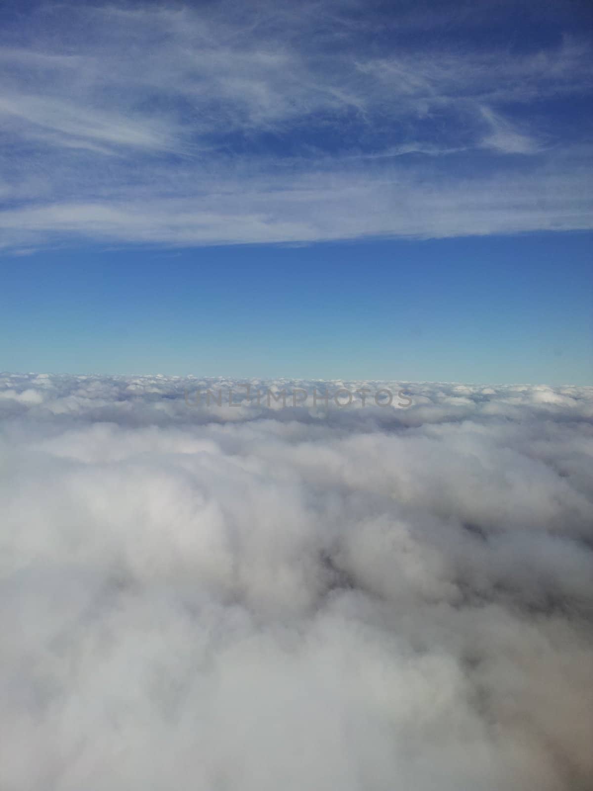 Aerial view of white clouds from airplane window.