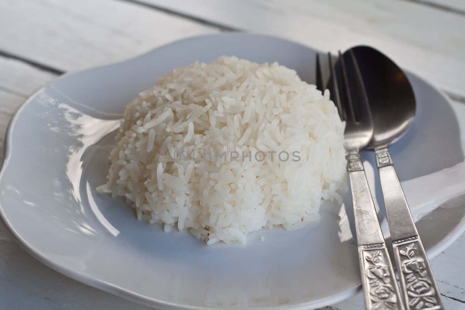 Rice on a white plate with utensils.