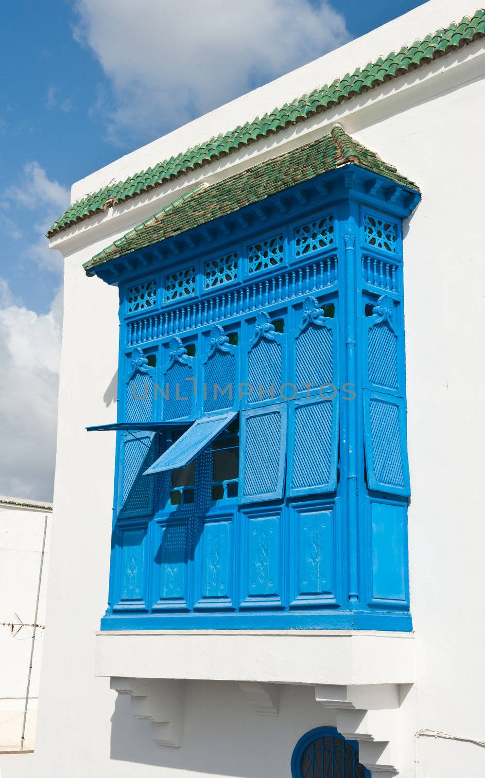 Beautiful ornamental blue windows on a white wall so typical for Tunisia 