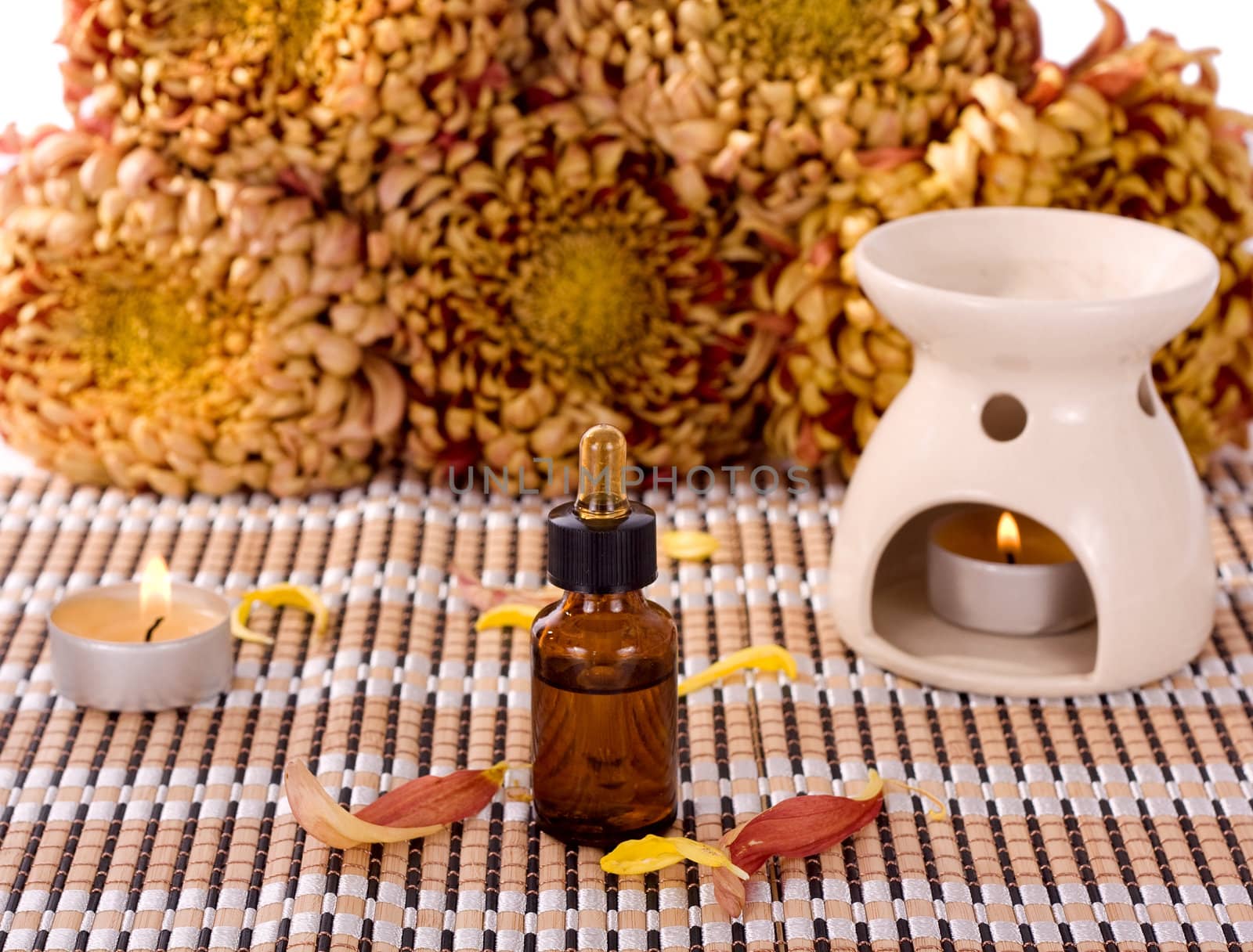 Aromatherapy oils and candles with small chrysanthemum flowers
