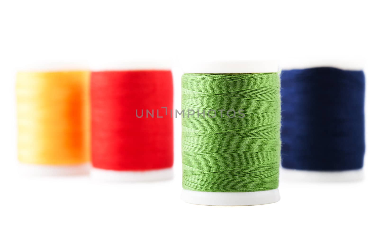 Four spools with green, yellow, blue and red thread