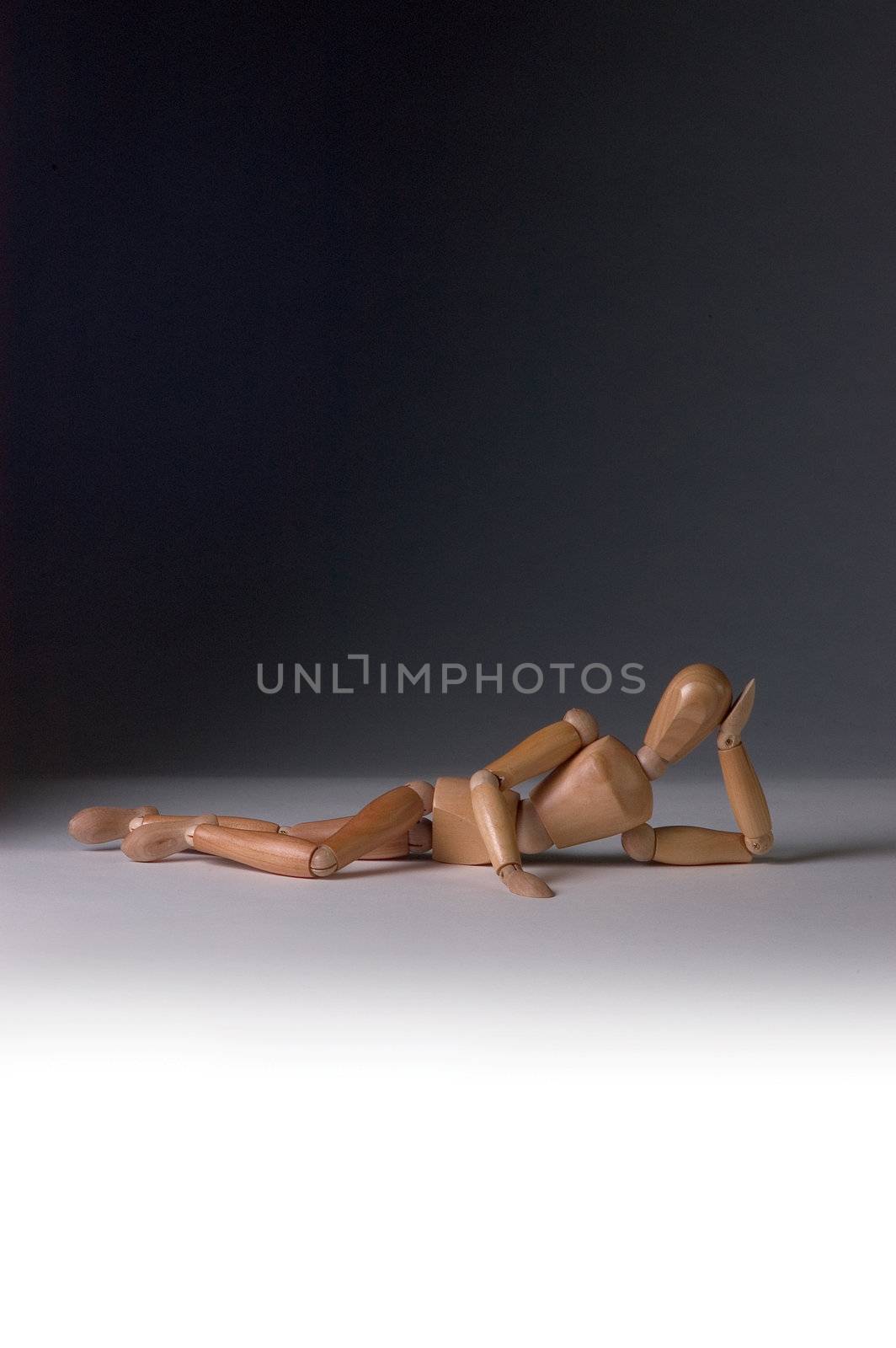 Wooden modelling mannequin in a sexy pose, reclined on one hand