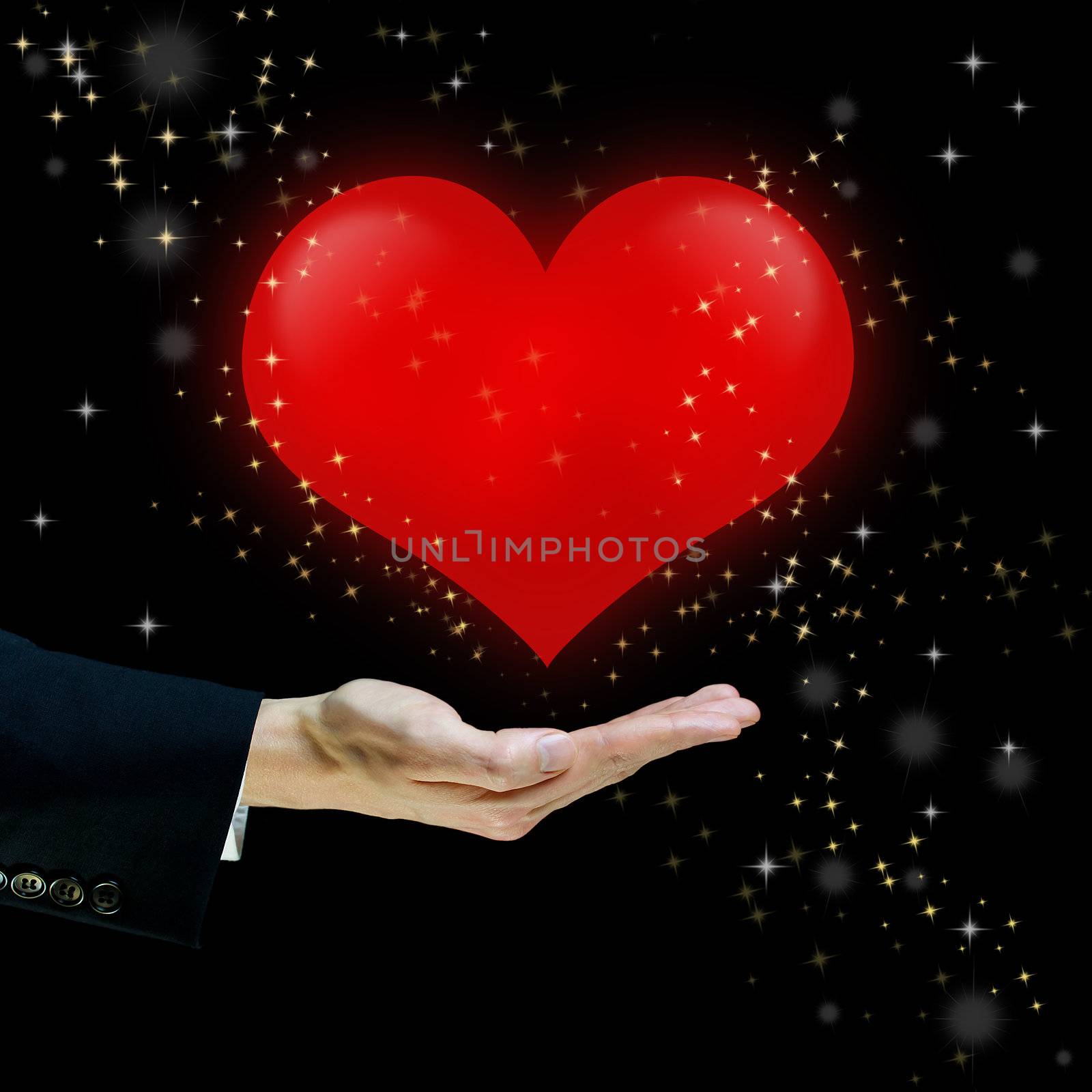 Red heart floating over a hand on black background with star dusts