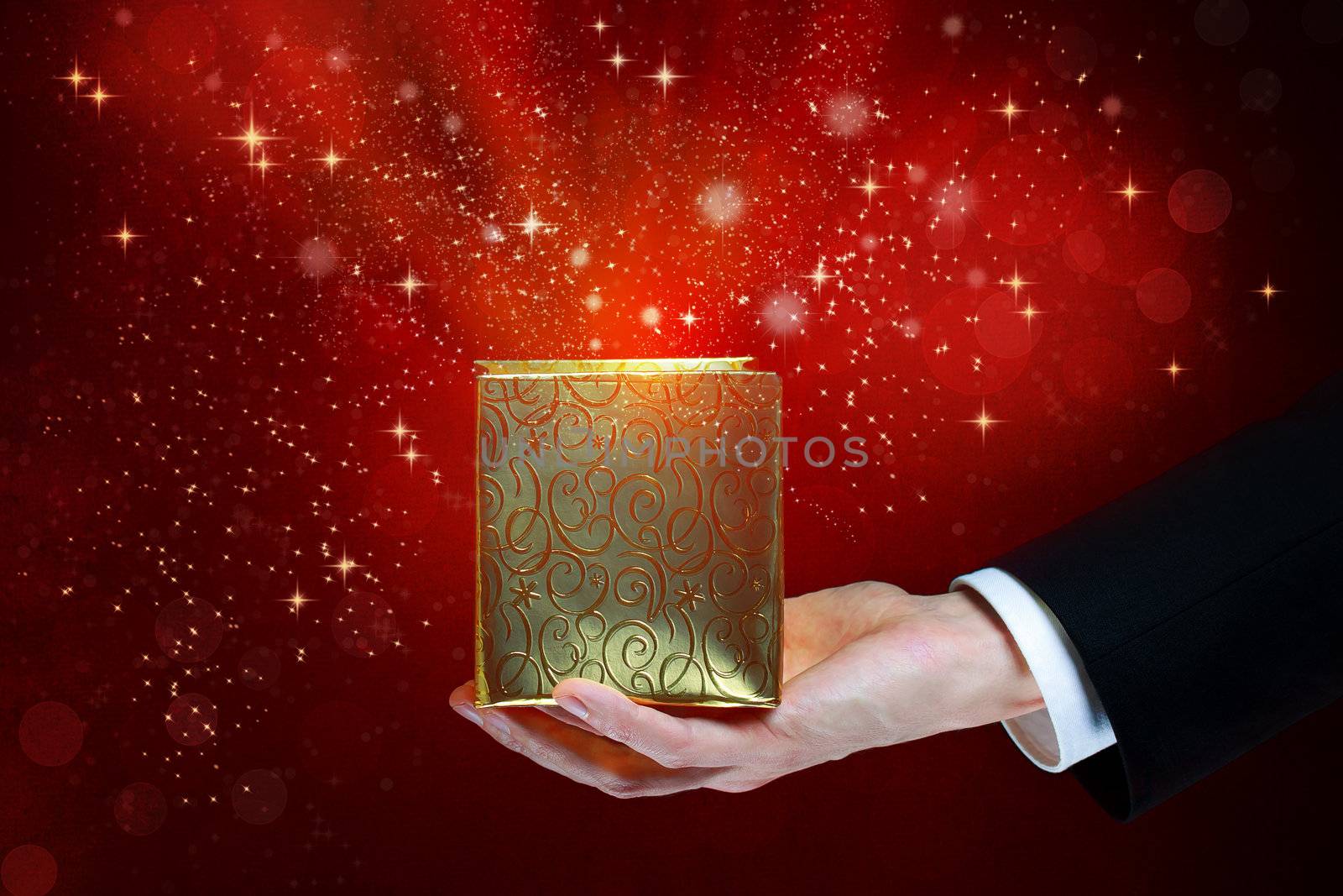 Business man holding a magic box on red shiny background