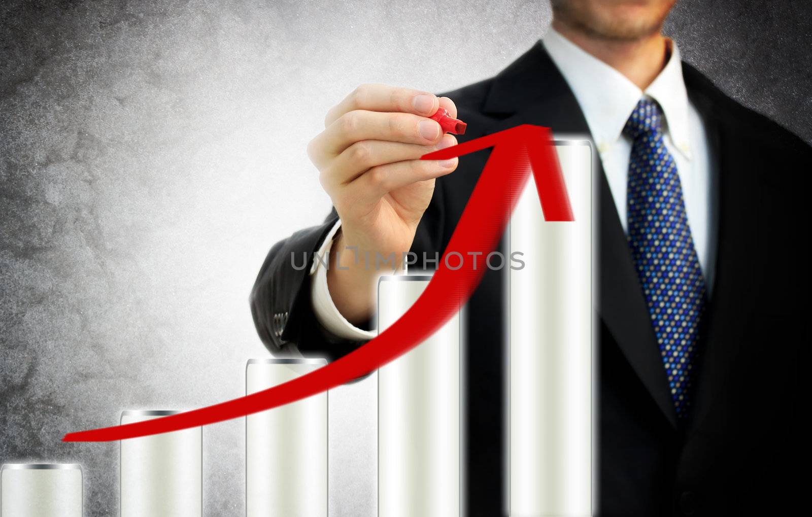 Businessman drawing a rising arrow on the top of bar graph representing growth