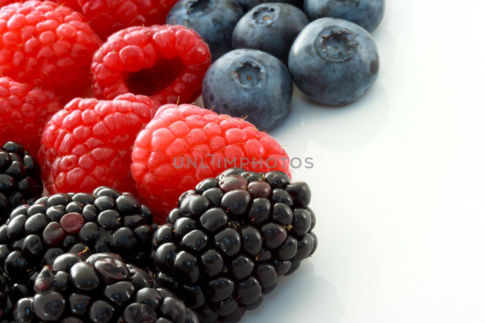 Raspberries, Blueberries and Blackberries on White Ceramic plate