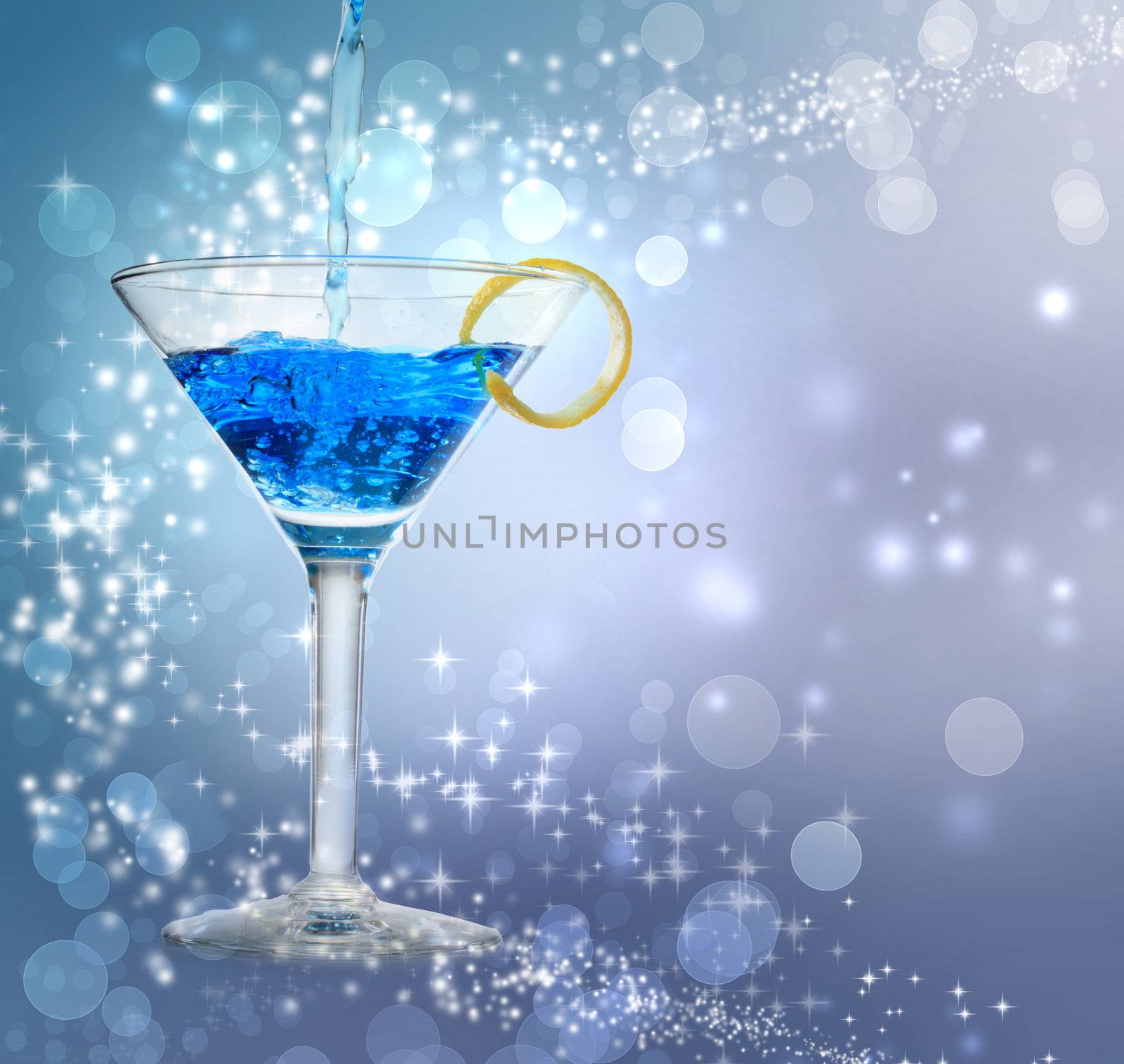  Blue cocktail being poured into a glass on abstract lights background