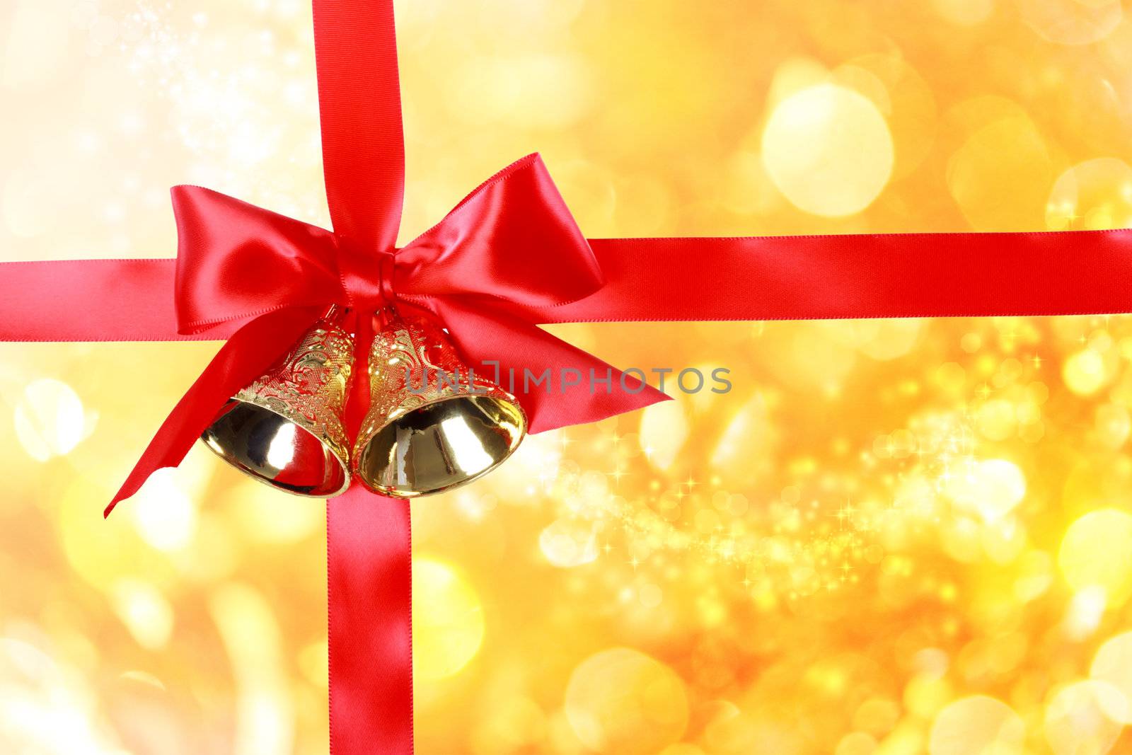 Red Christmas Ribbon with Bells over Golden Christmas Bokeh Lights