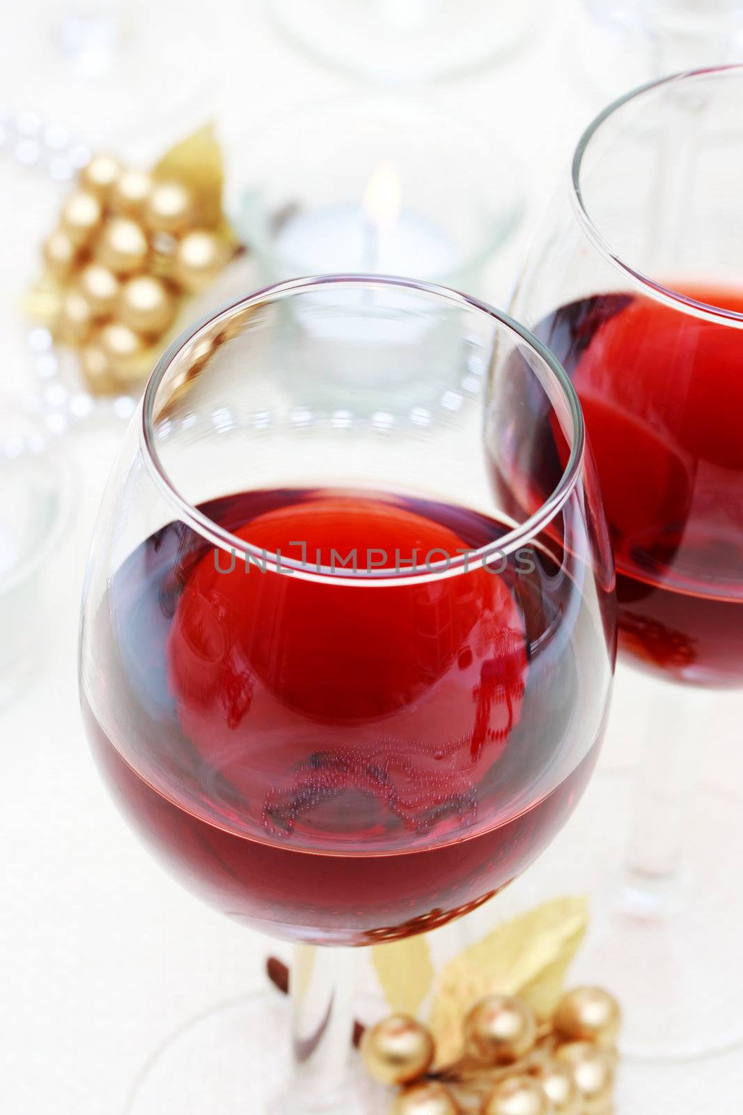 Two red wine glasses on the table with ornaments