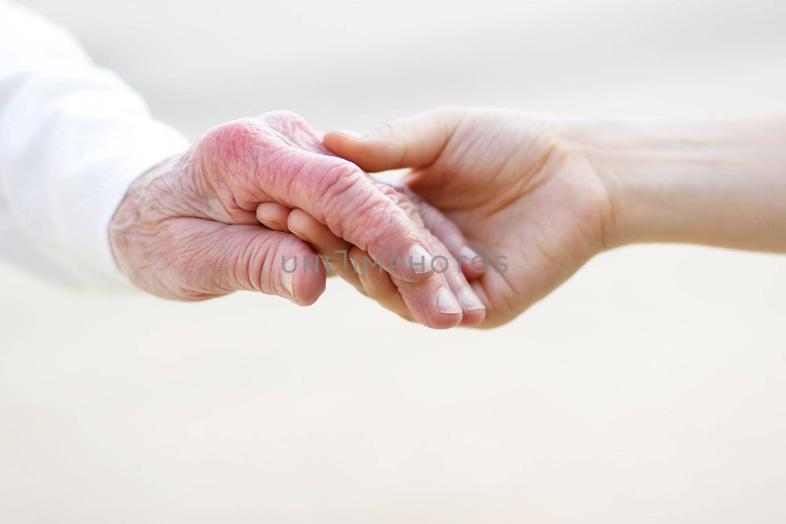 Senior lady and young women holding hands 