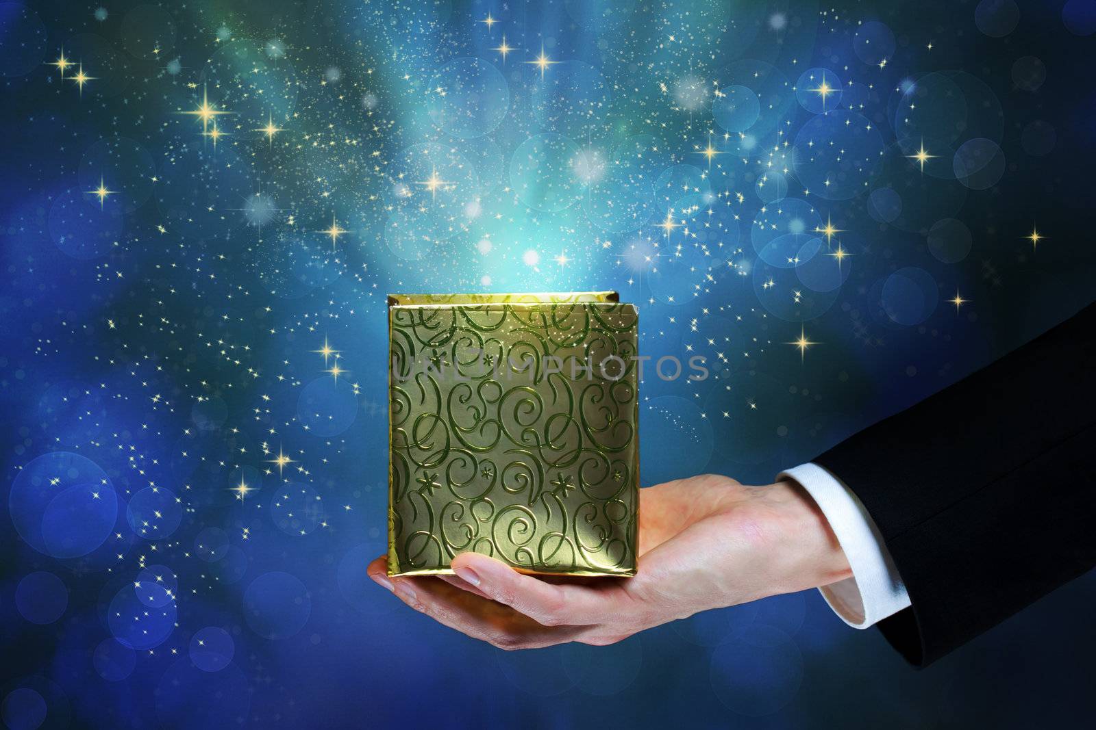 Business man holding a magic box on shiny blue background